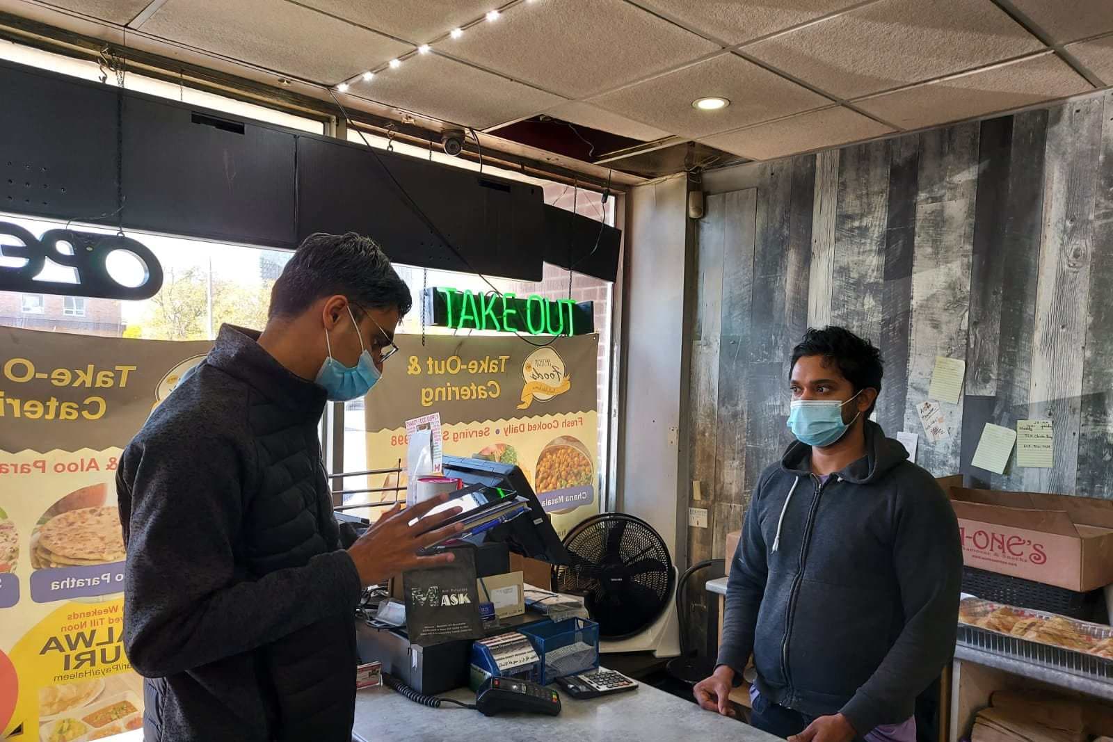 a canvasser talking to a shop owner.