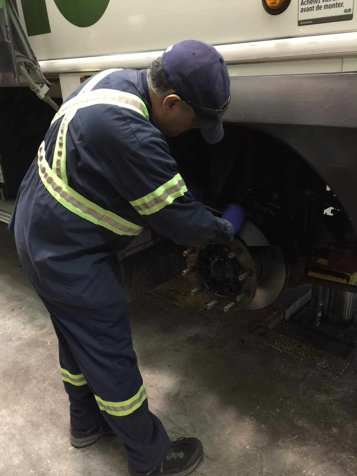 A mechanic works on a tire of a bus.