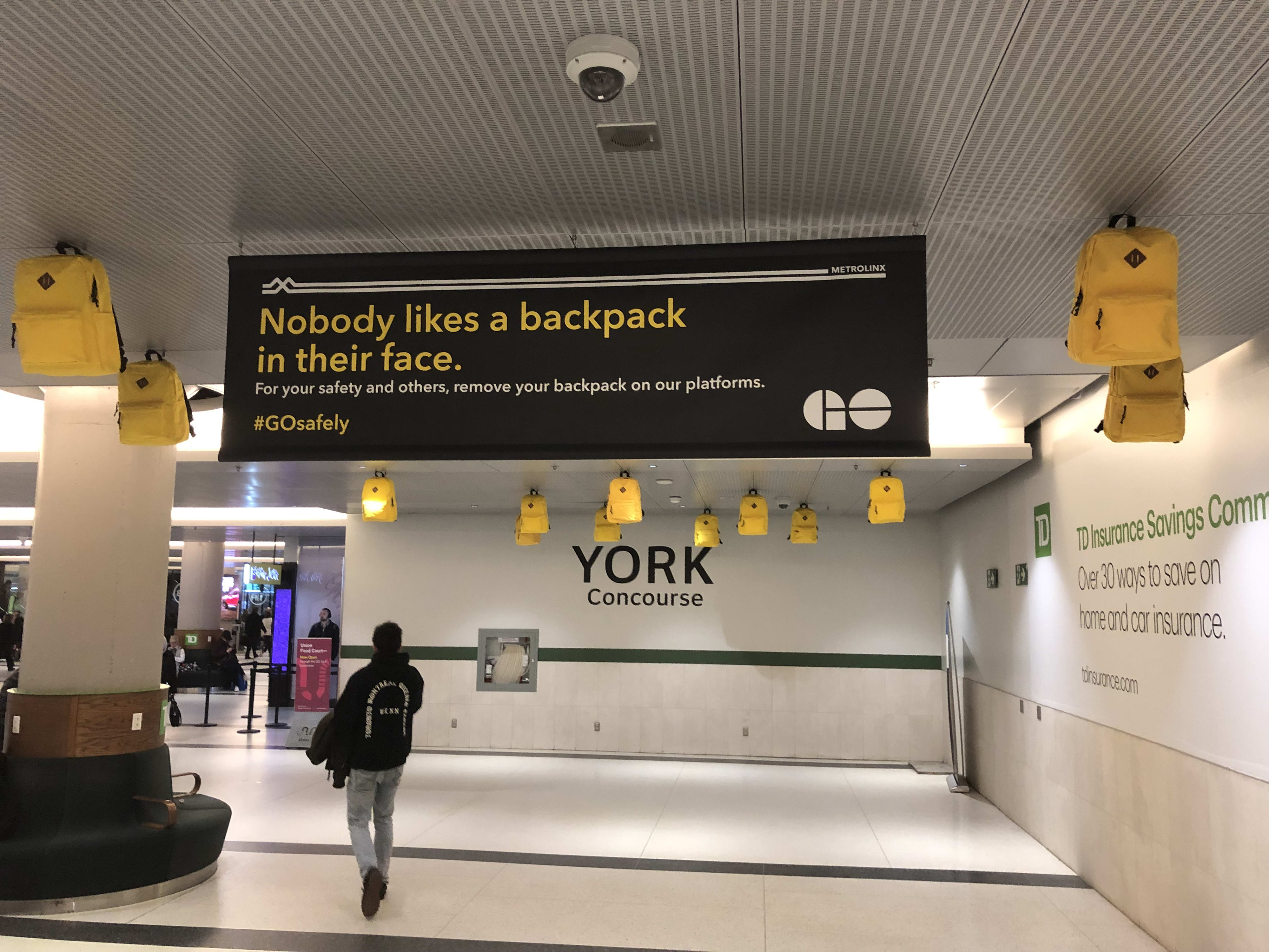 Backpacks are suspended from the ceiling, as a reminder that 'Nobody likes a backpack in their fa...