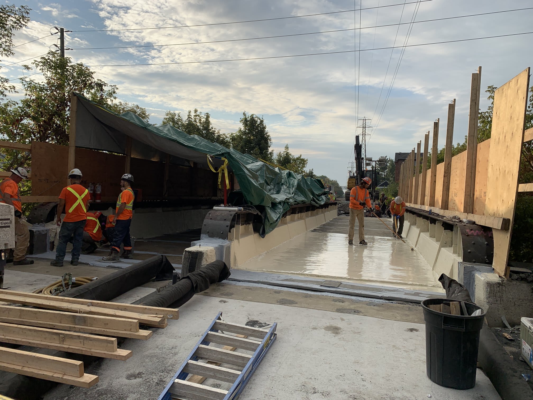 A view of the top of the bridge, with crews applying a new layer on the foundation.