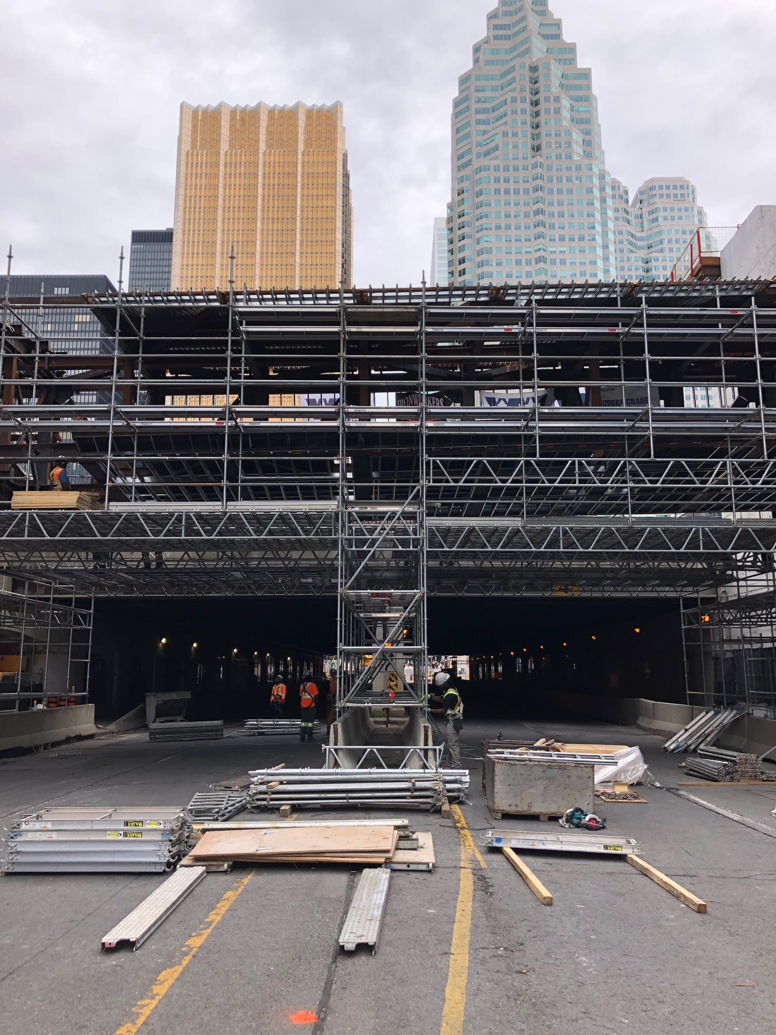 Supports and metal poles frame in the bridge, as crews work nearby.