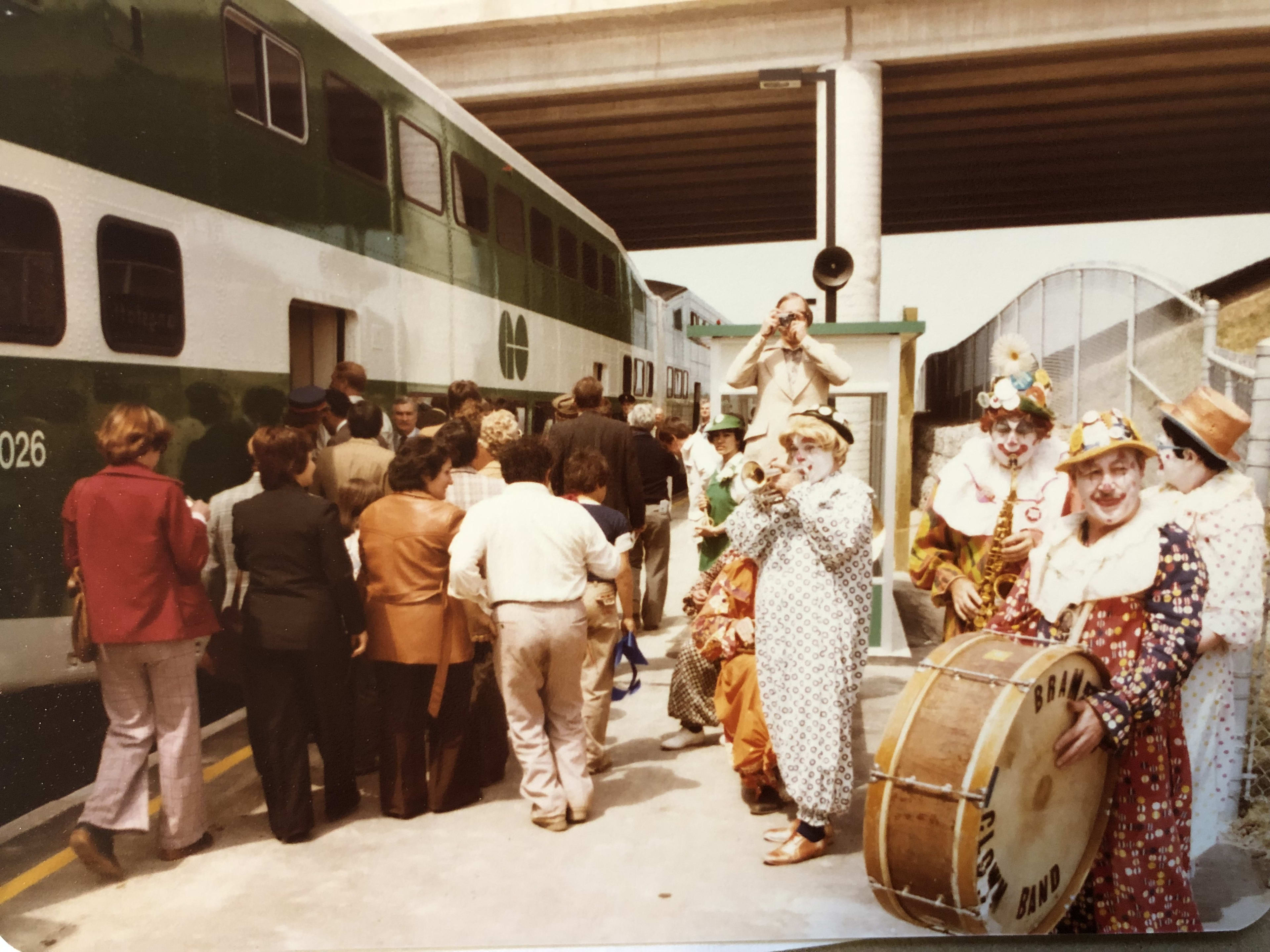 A clown band plays as customers board a GO train.