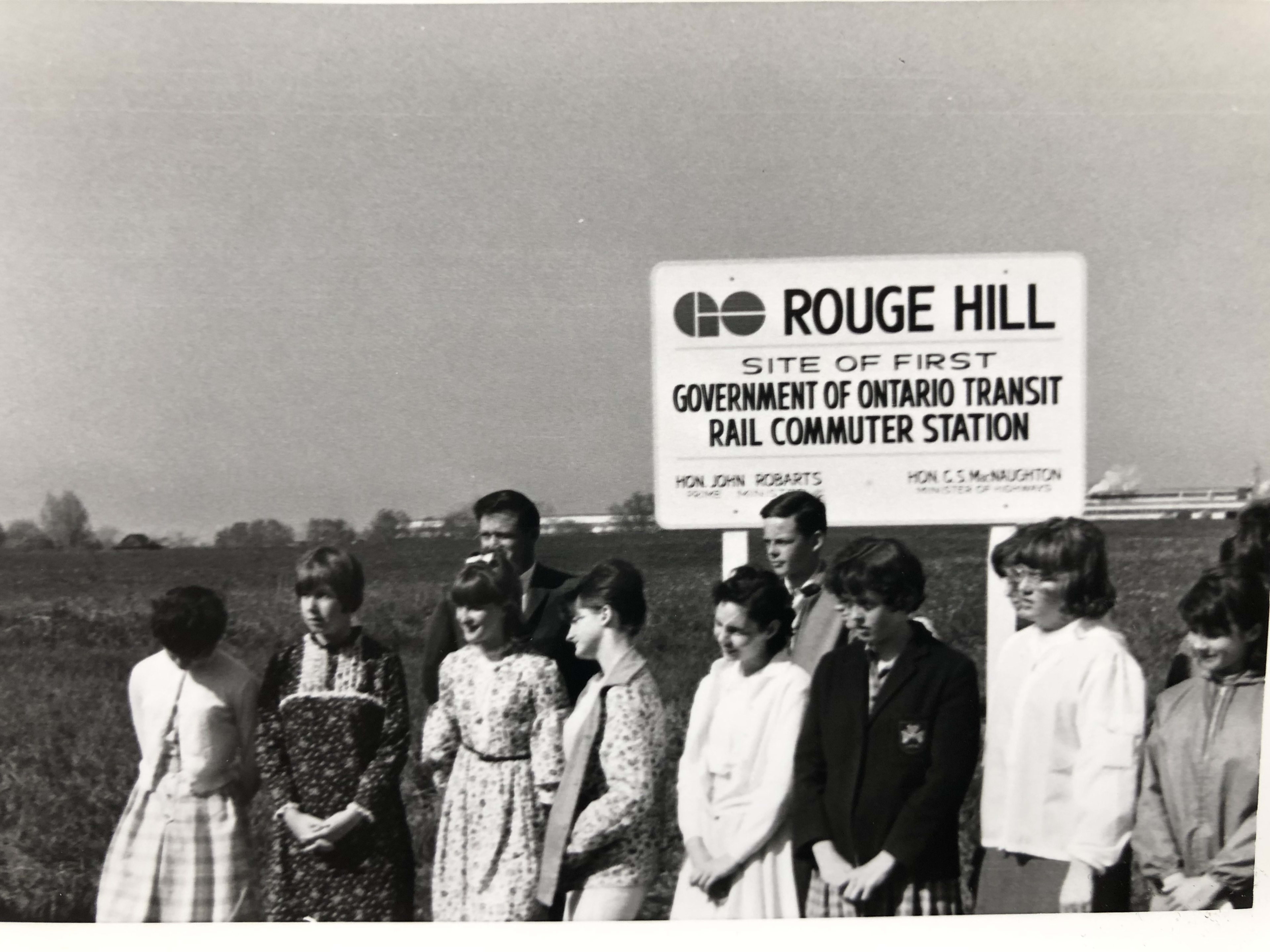 Students stand in front of a large sign promoting the Rouge Hill site.