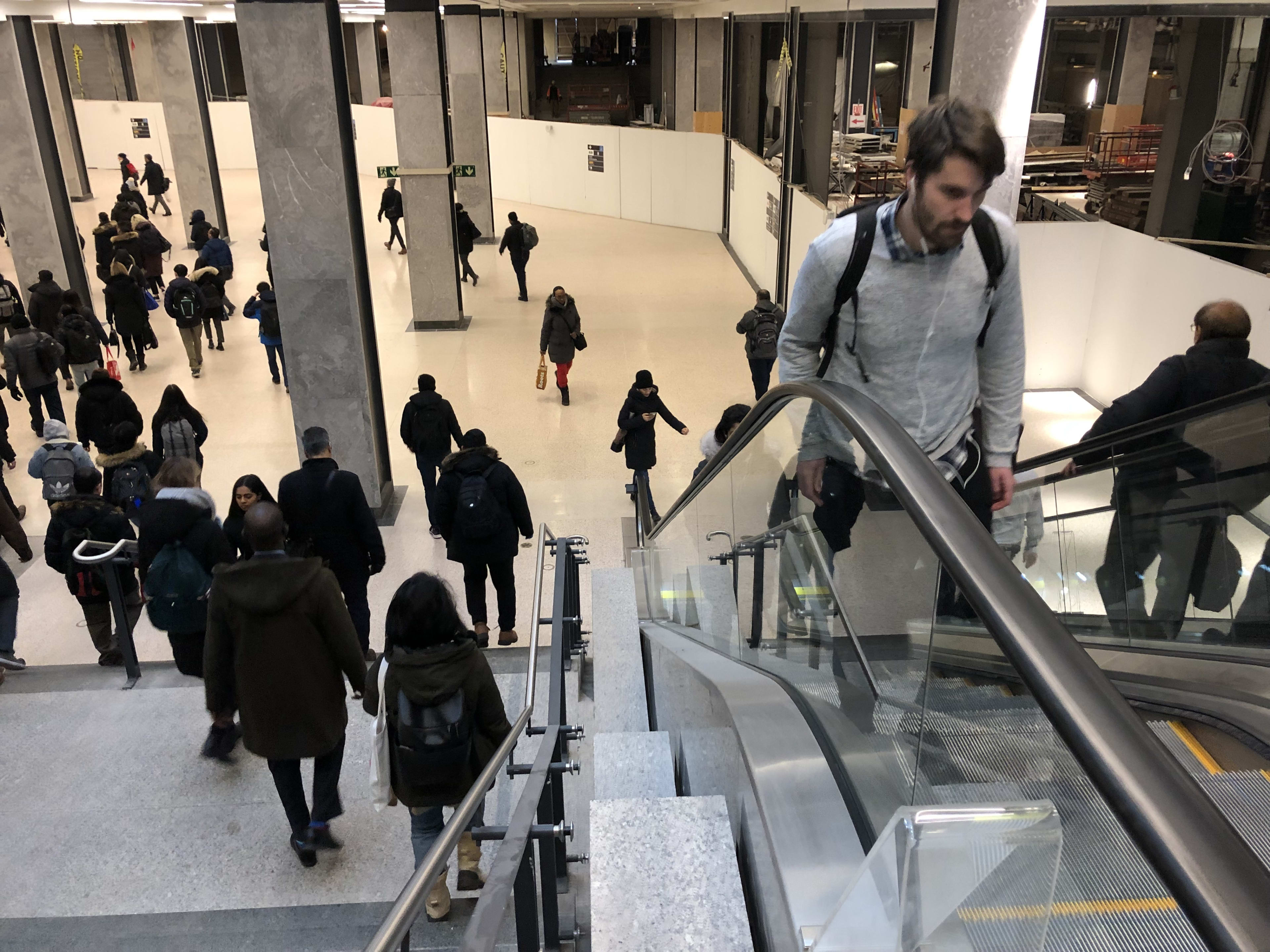 Travellers go down the stairs and up the escalators.