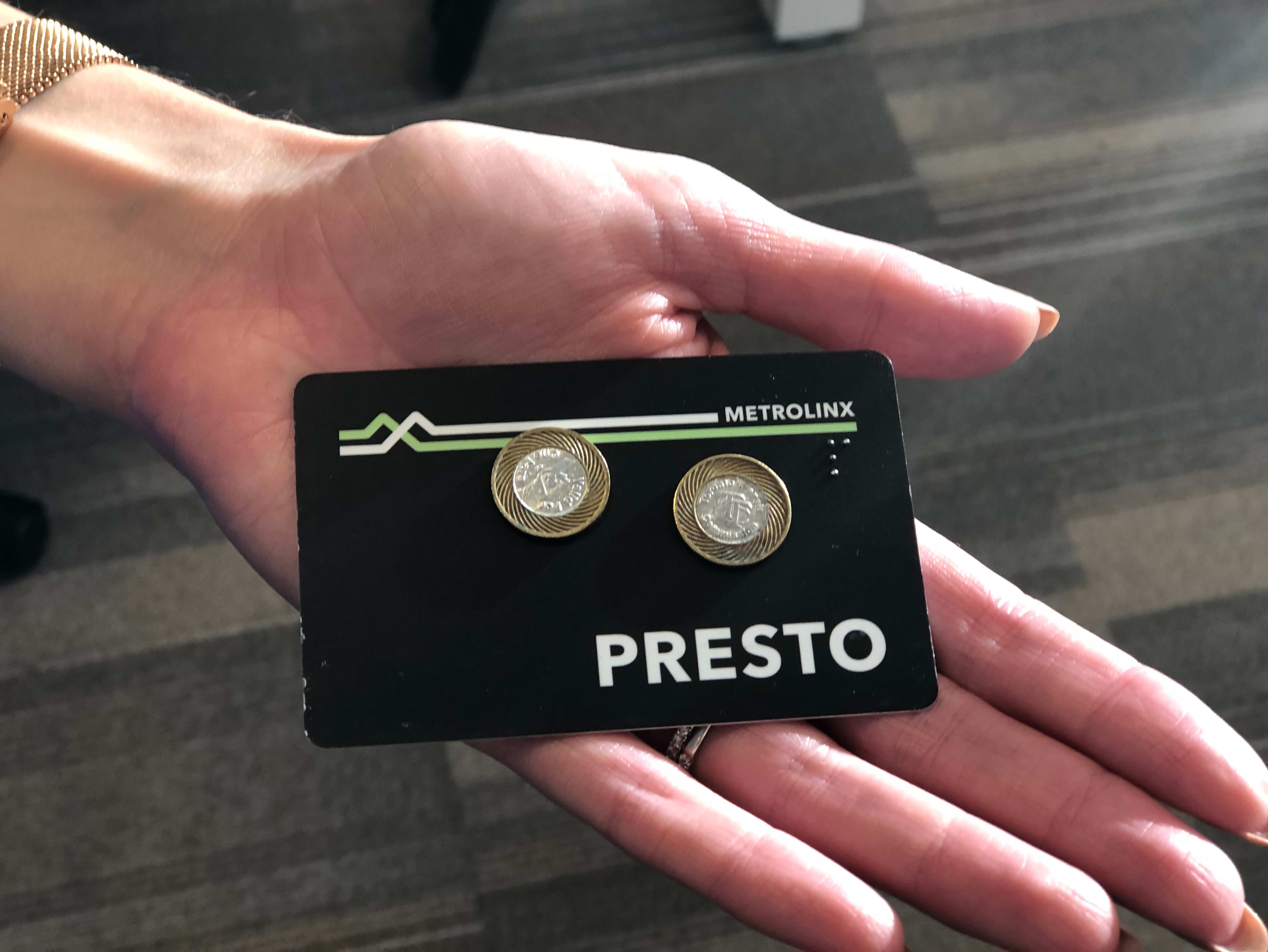 A PRESTO card and TTC tokens on a person's hand.