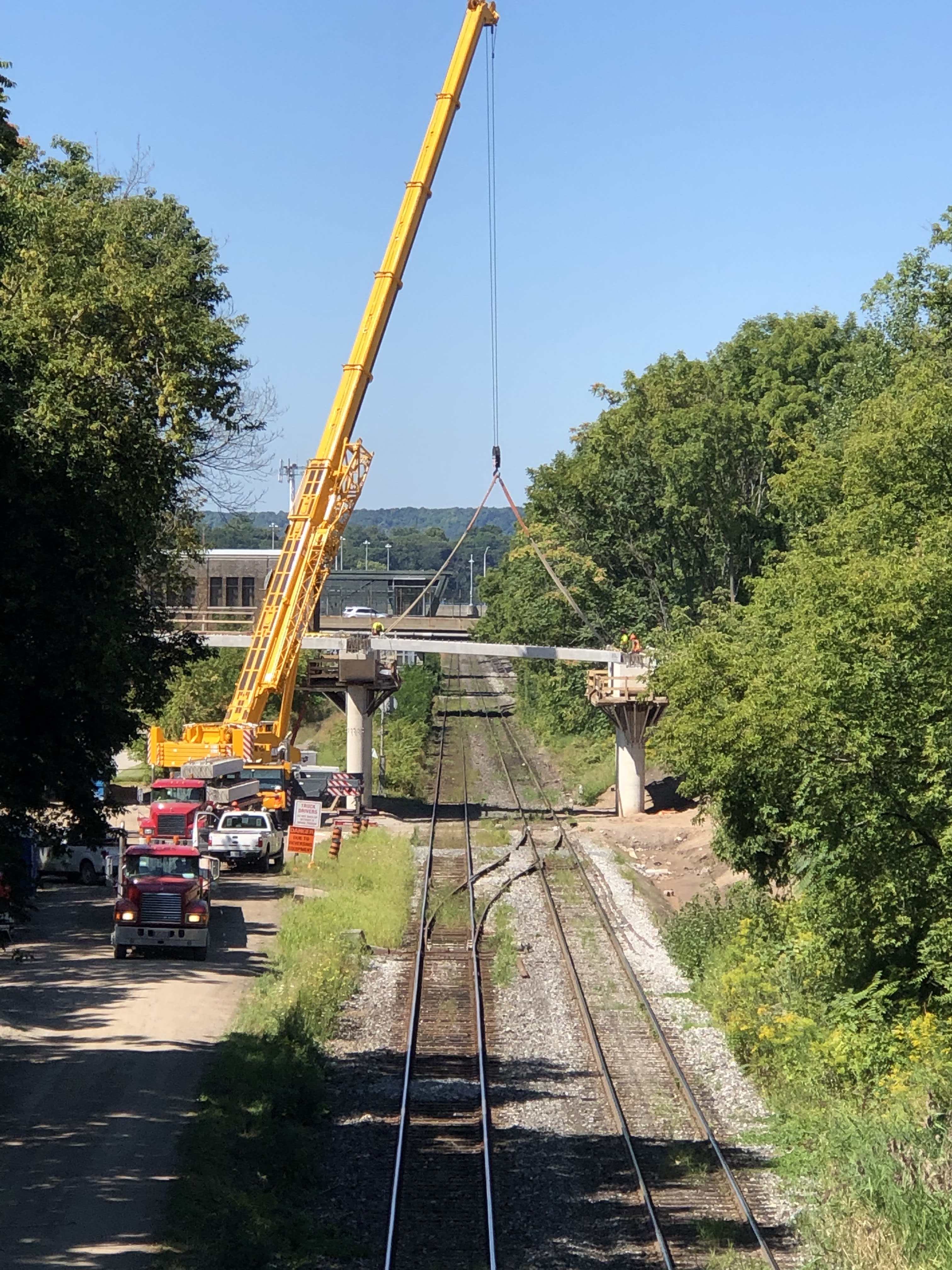 A massive crane lifts a piece of bridge into place near Hamilton's West Harbour GO Station
