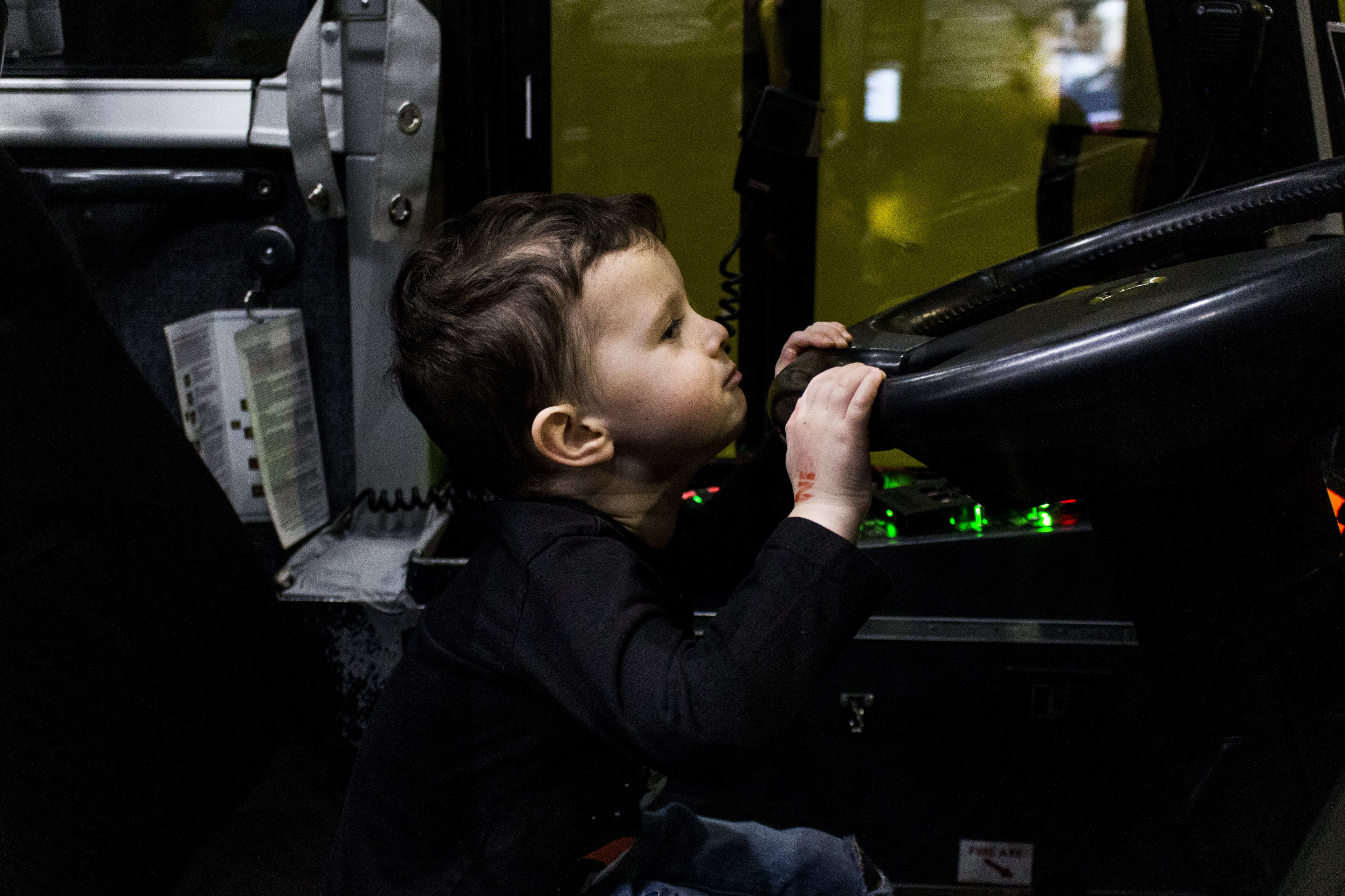 A young boy struggles to see over the wheel of the GO bus.