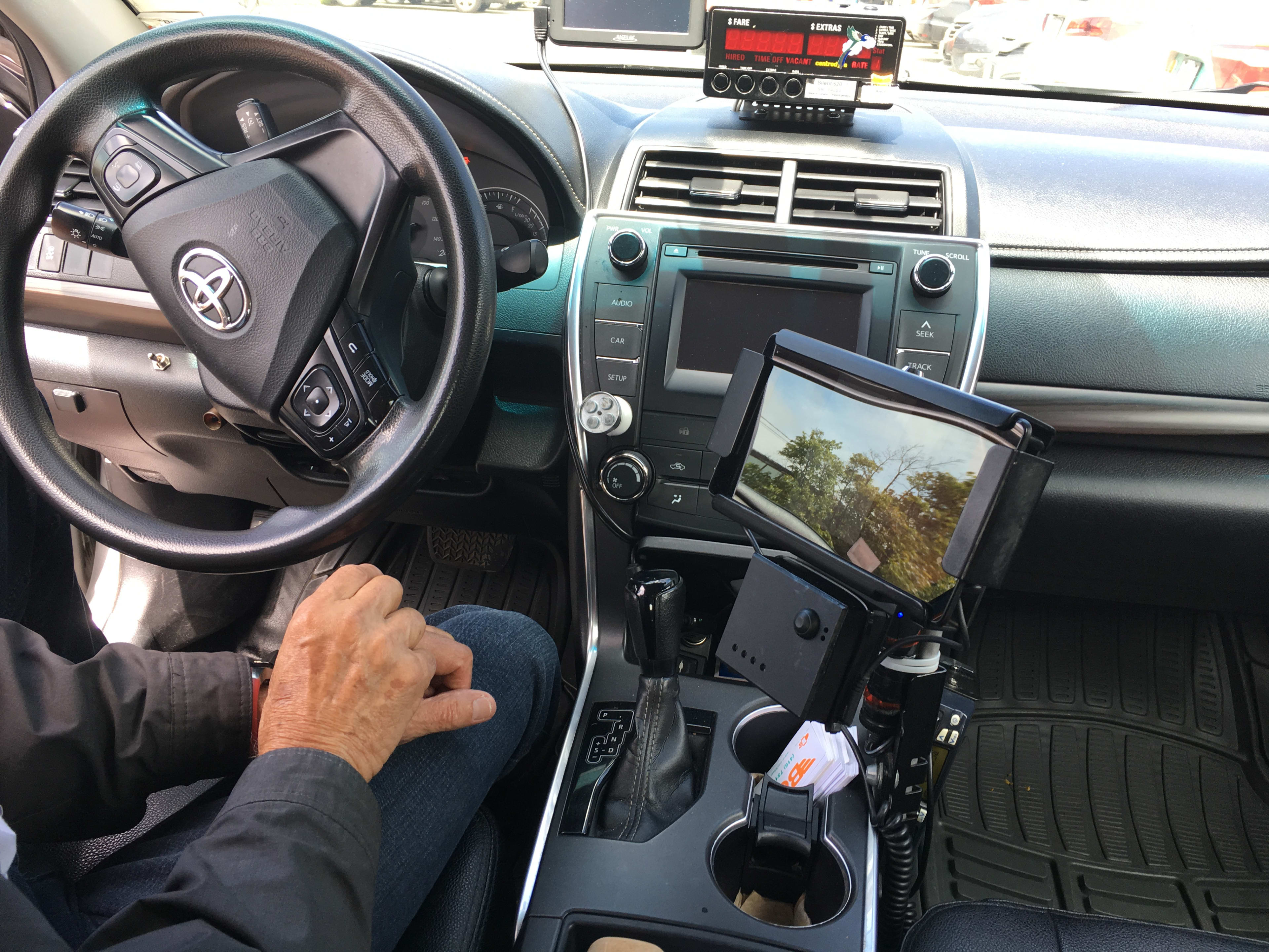 A driver sits in his vehicle, beside a payment system.