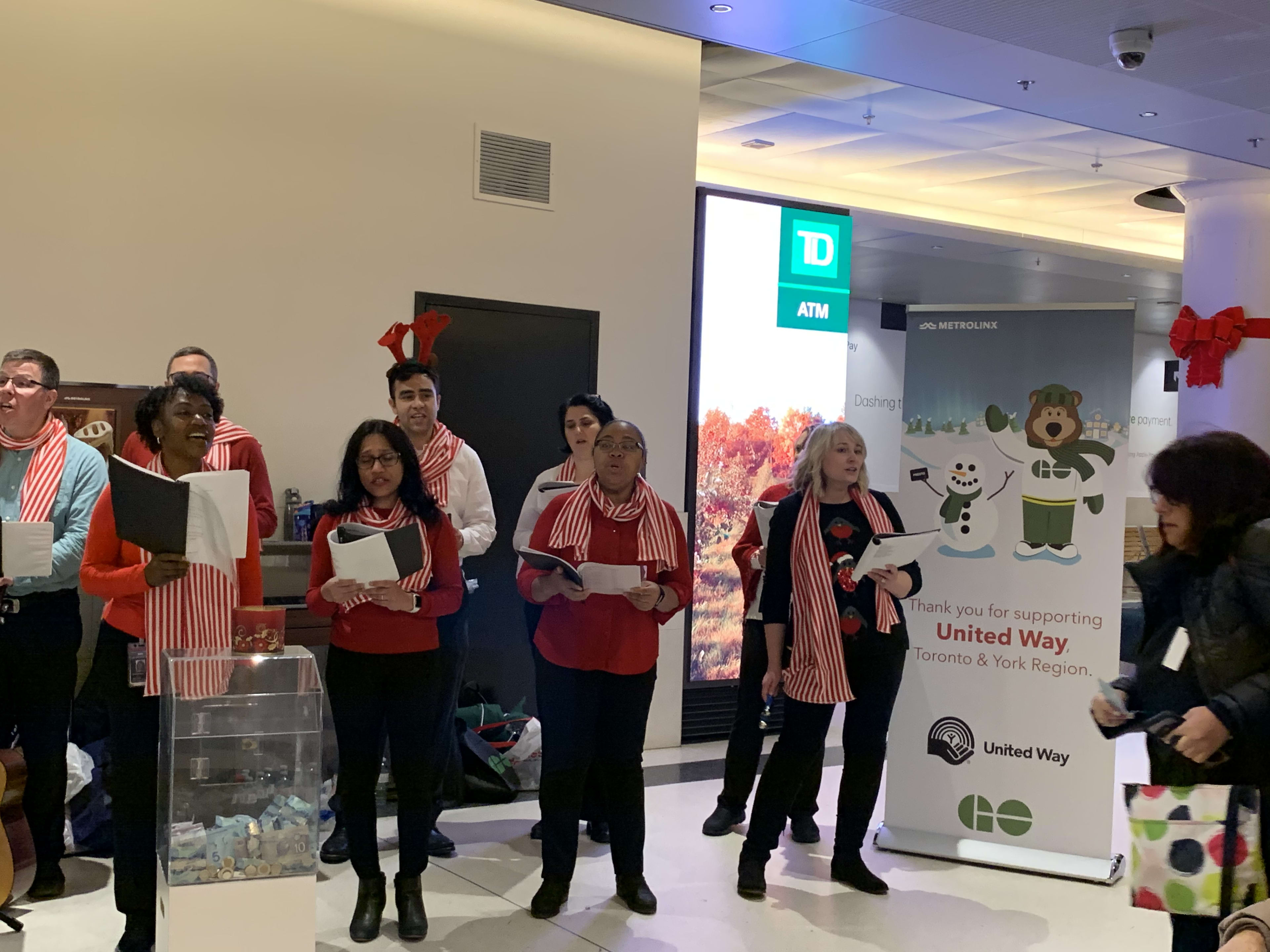 Group of people singing Christmas carols in the GO Concourse at Union Station