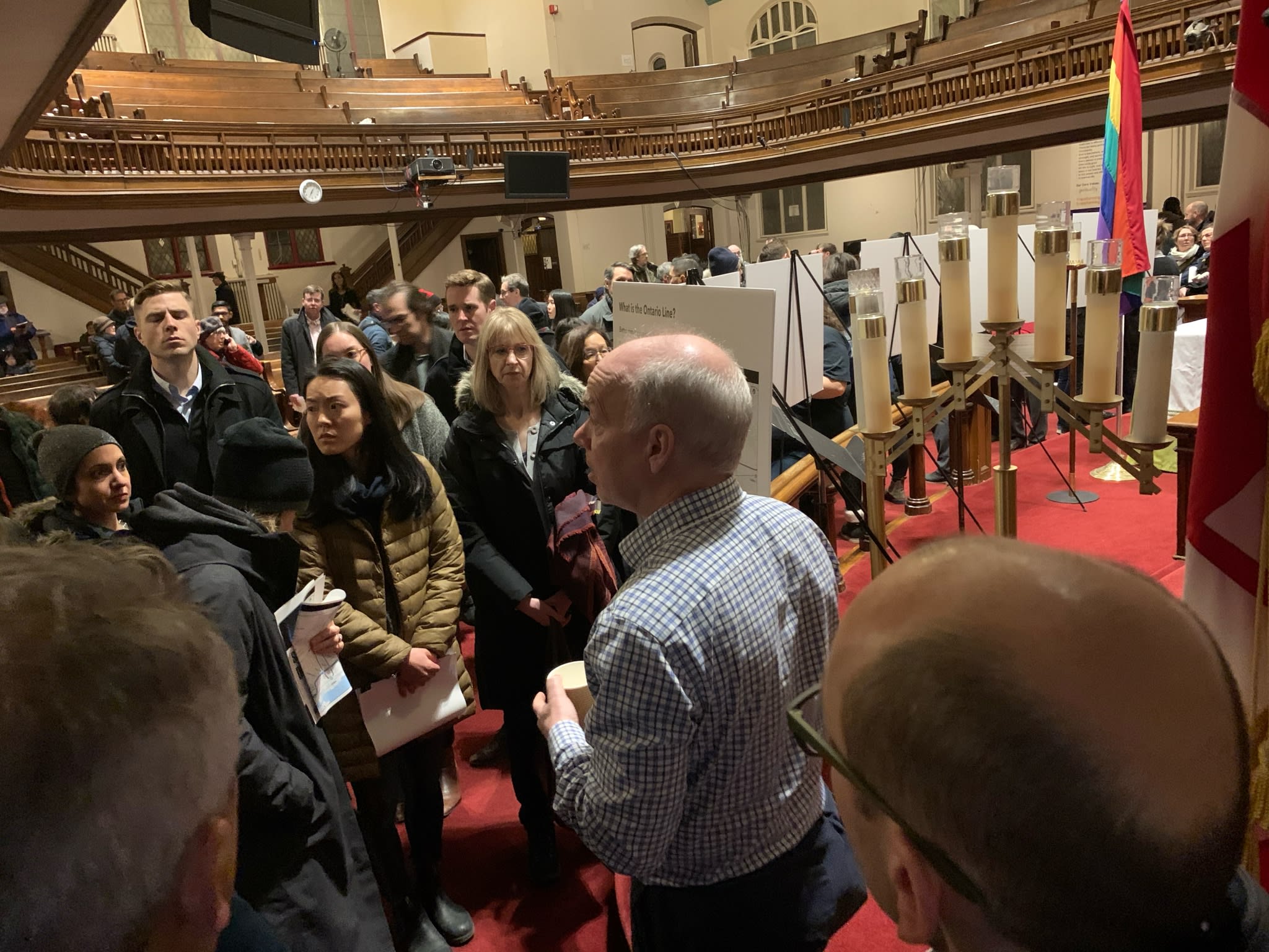 People gather in a church for a public meeting.