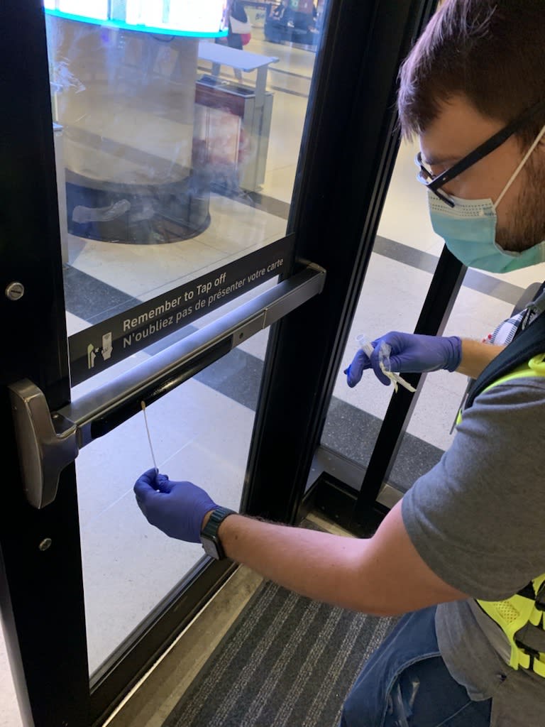 a person taking a sample from a door.