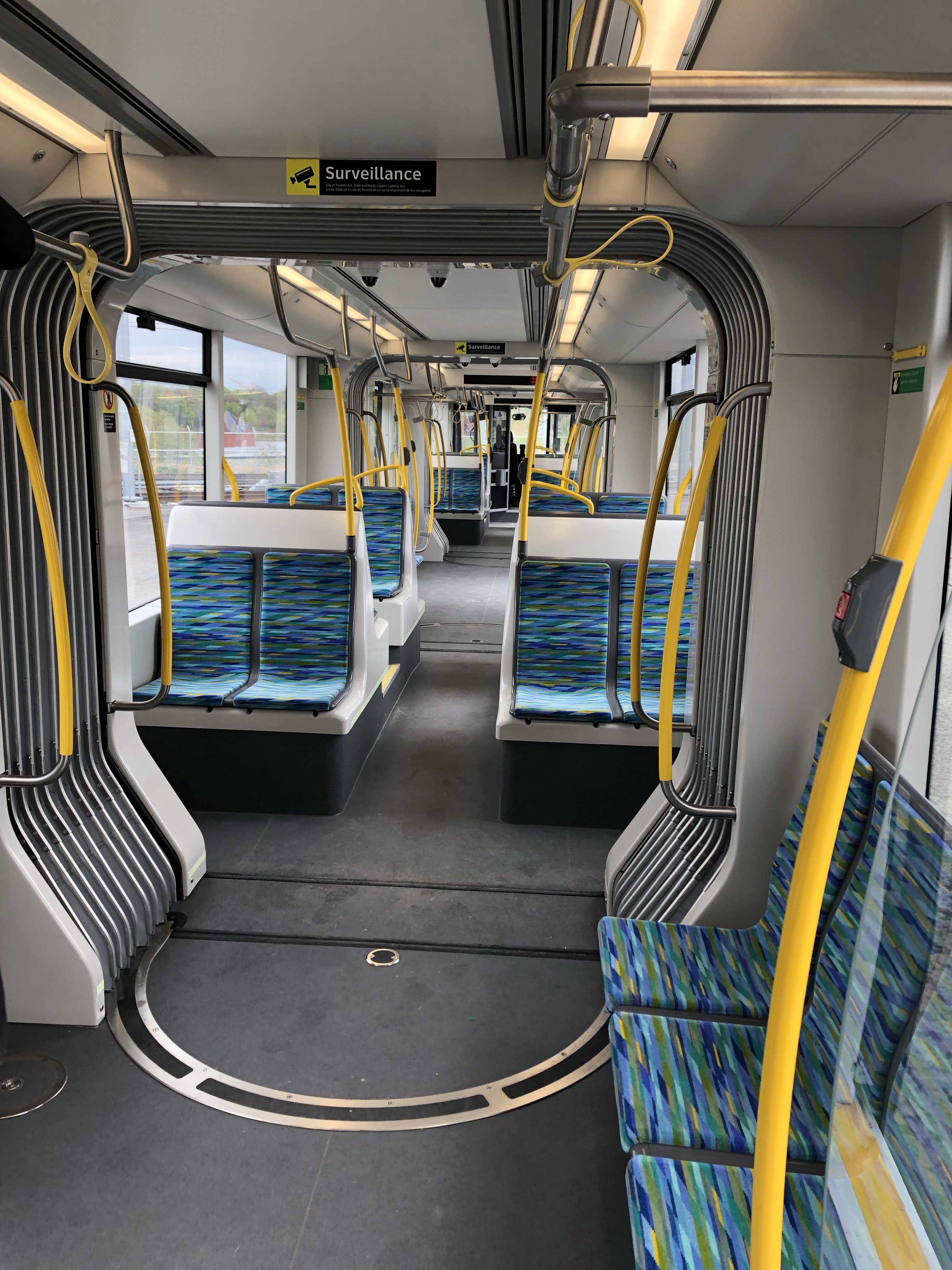 The inside of the LRV with blue and green seats and plenty of standing room.