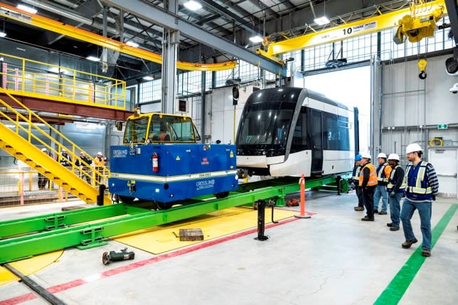 Crews inspect an arriving LRV inside a Crosstown facility. the interior is large and bright, as t...