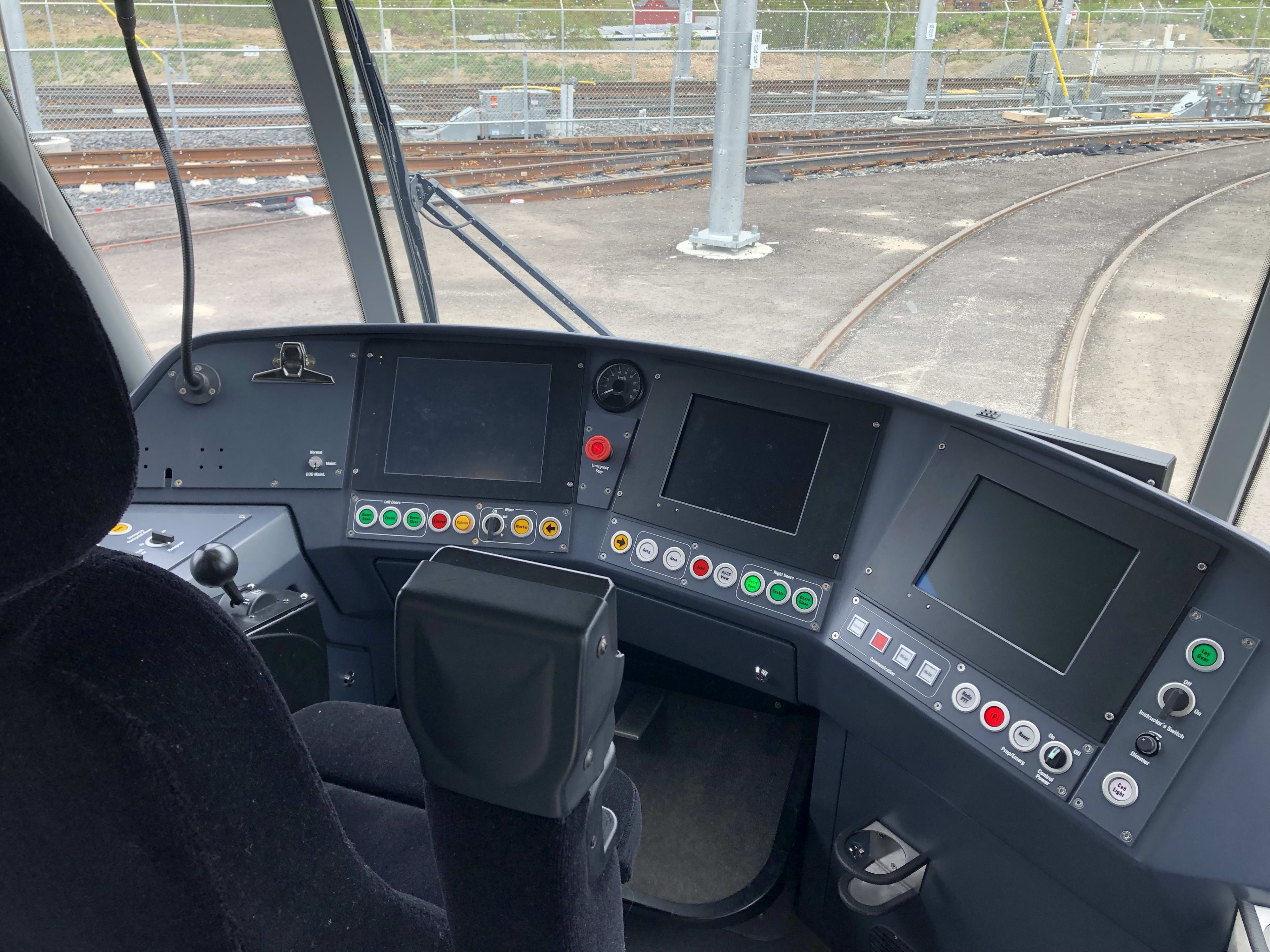 The driver's seat is shown, with three screens and plenty of buttons.
