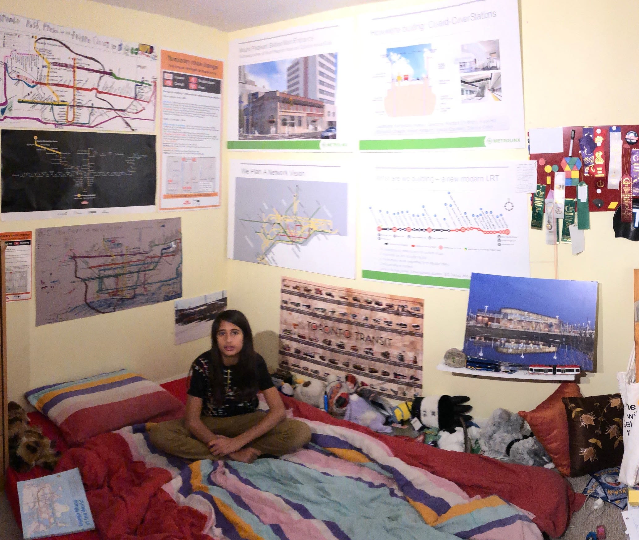 The inside of a bedroom with walls decorated with transit related material.
