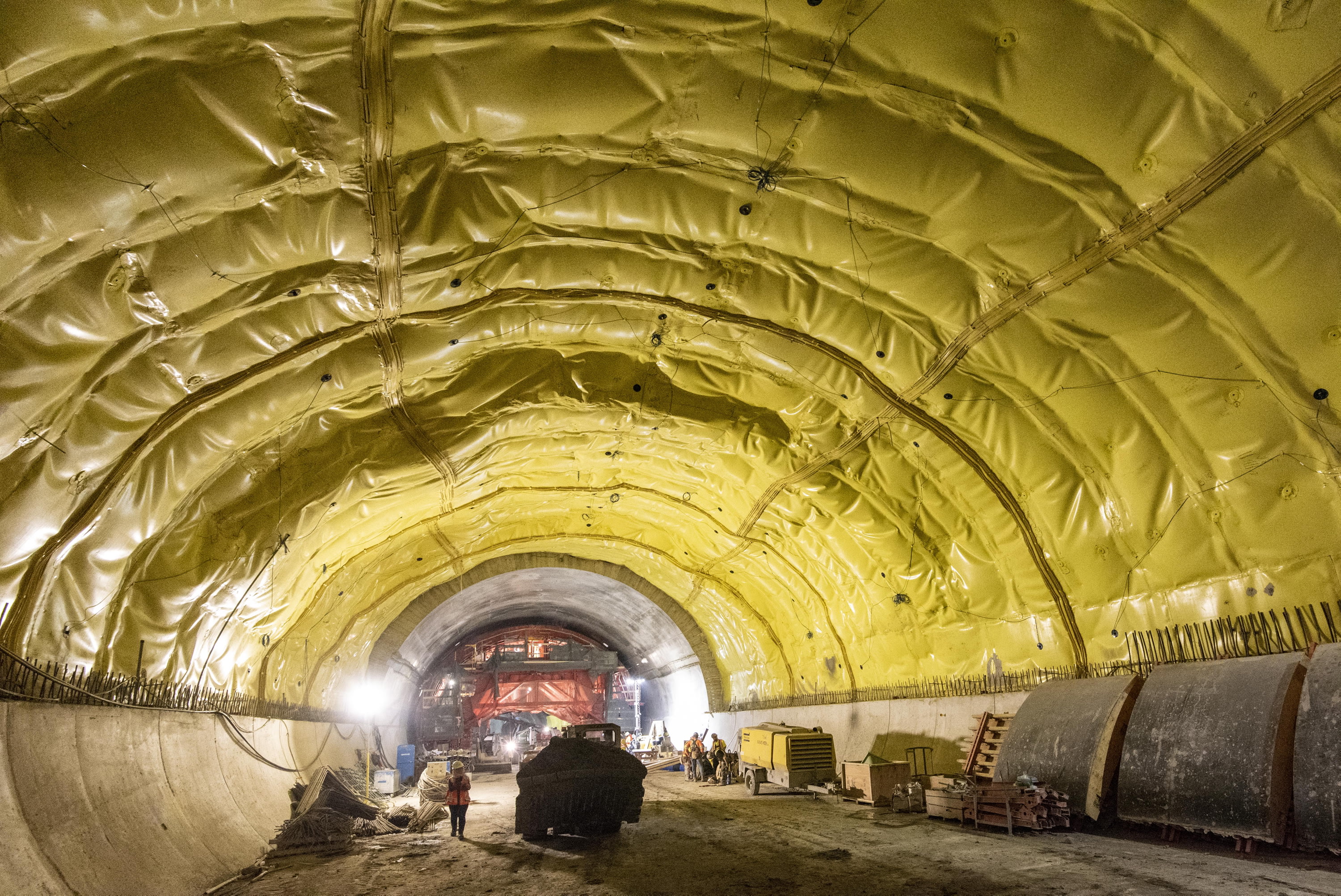 A tunnel is seen shieled by a yellow, fabric-like waterproof coating.