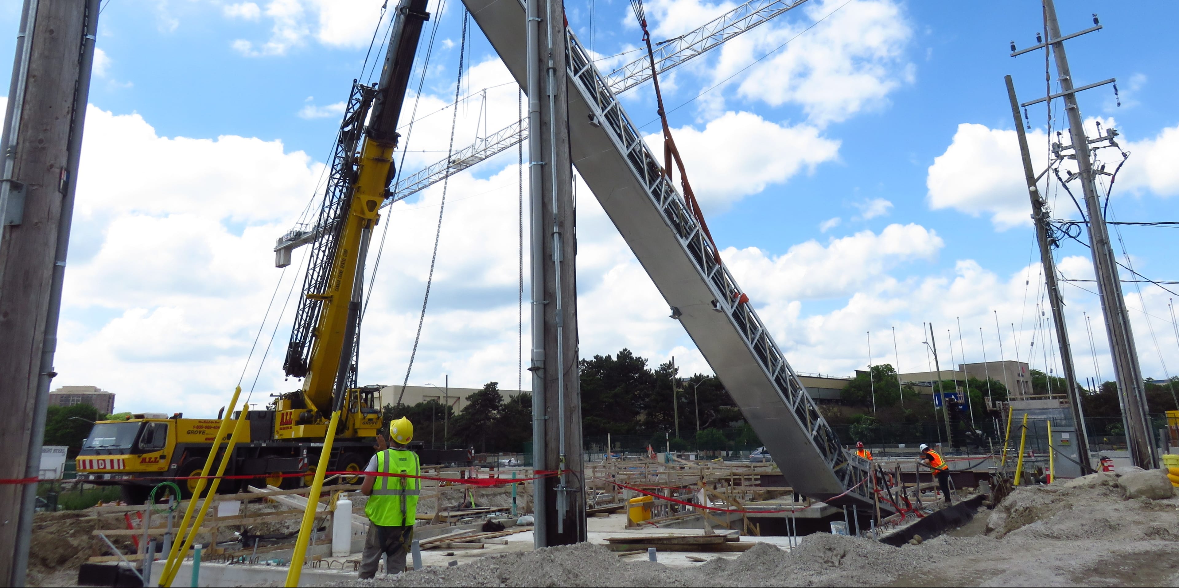 An escalator is lowered into the construction site for Science Centre Station by a giant crane.