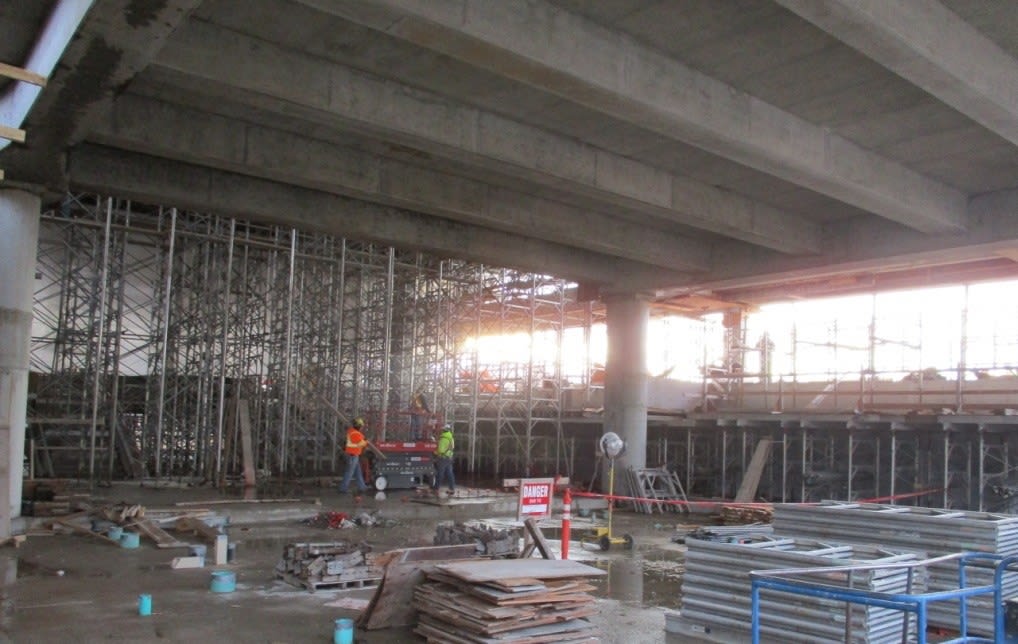 Workers work inside the concrete shell of the station.
