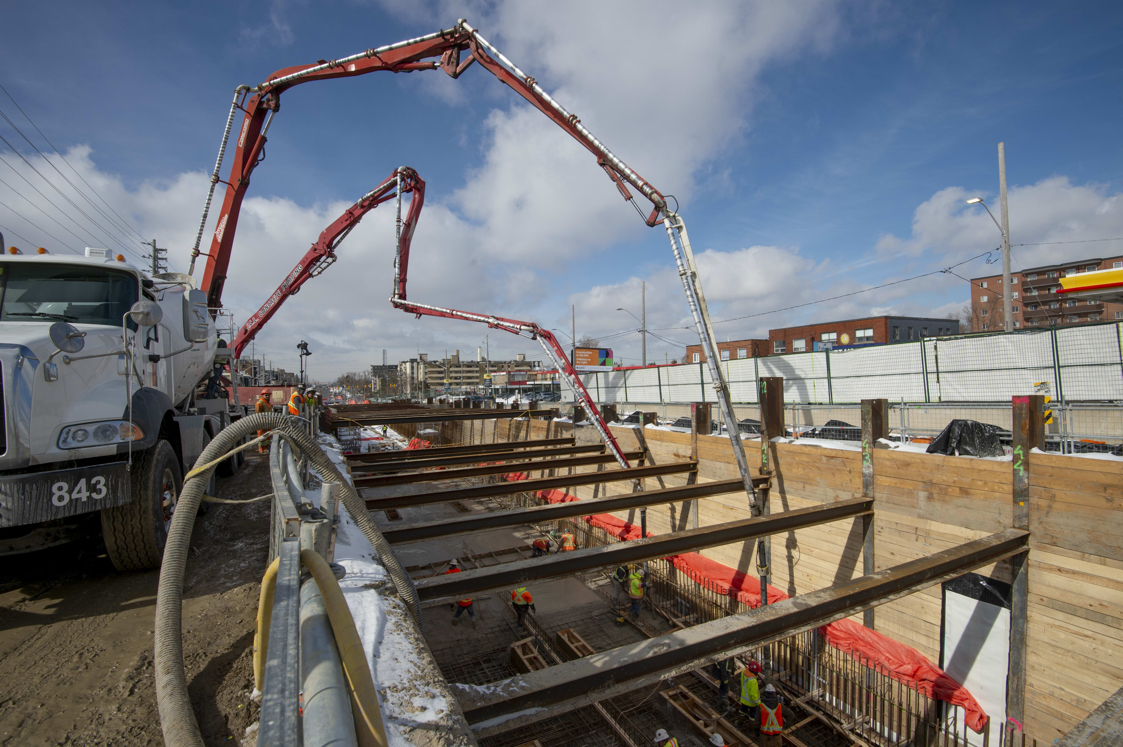 A large truck pumps concrete into a pit at Kennedy station.