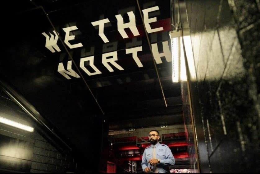Khan walks under a large banner that reads 'We the North'.