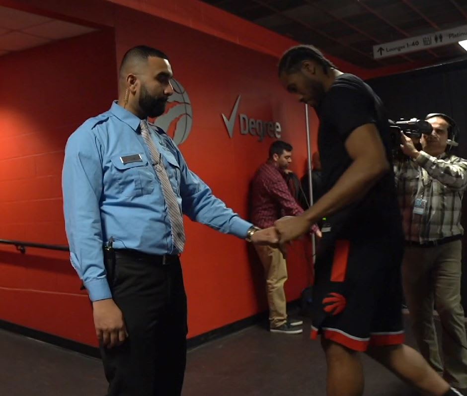 Zohaib Khan reachs to bump fists with player Kawhi Leonard, as the Raptors head to the dressing r...