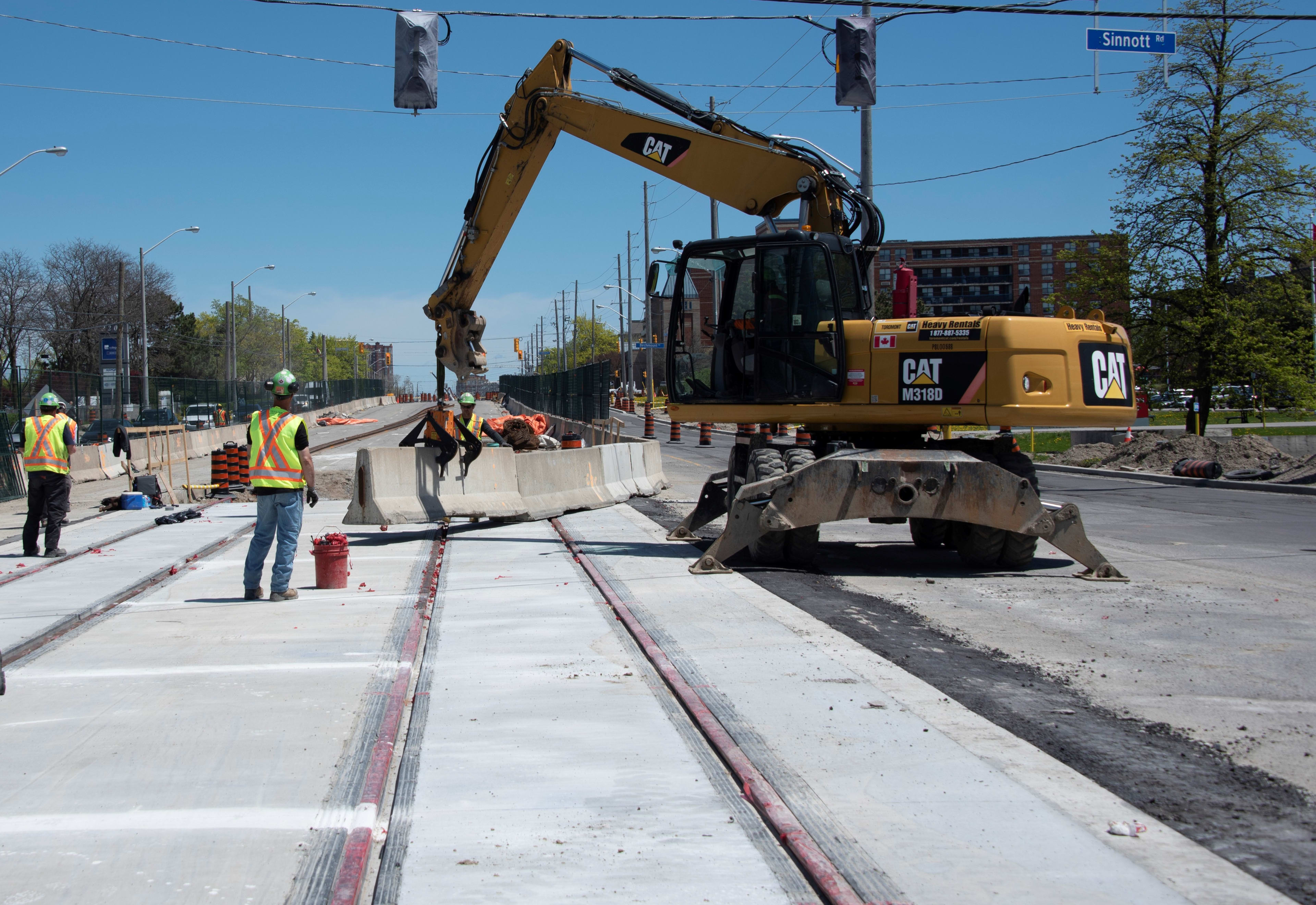 A tractor moves a concrete barrier while working on the Crosstown project.