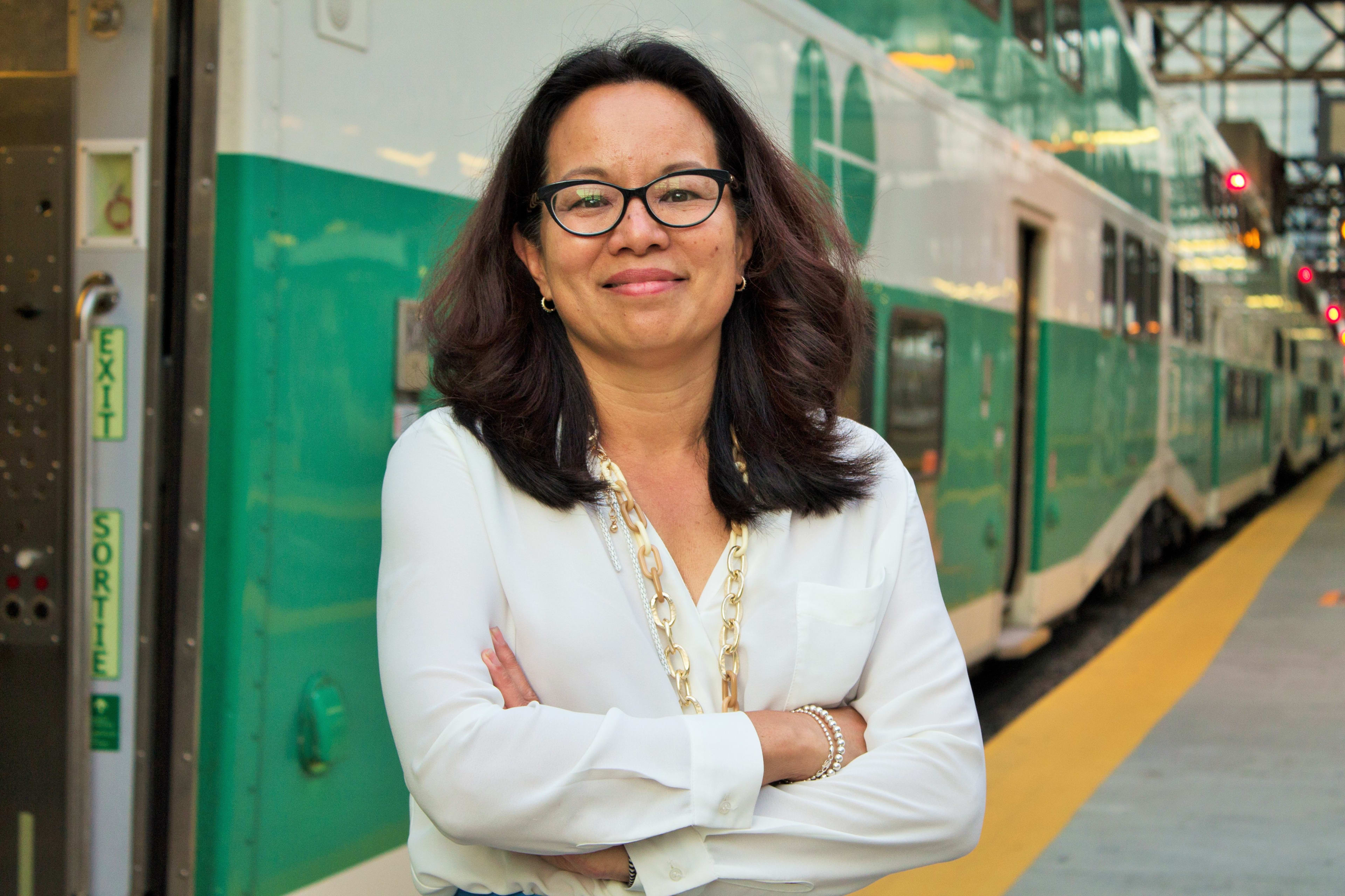 Leslie Woo poses next to a GO Train.