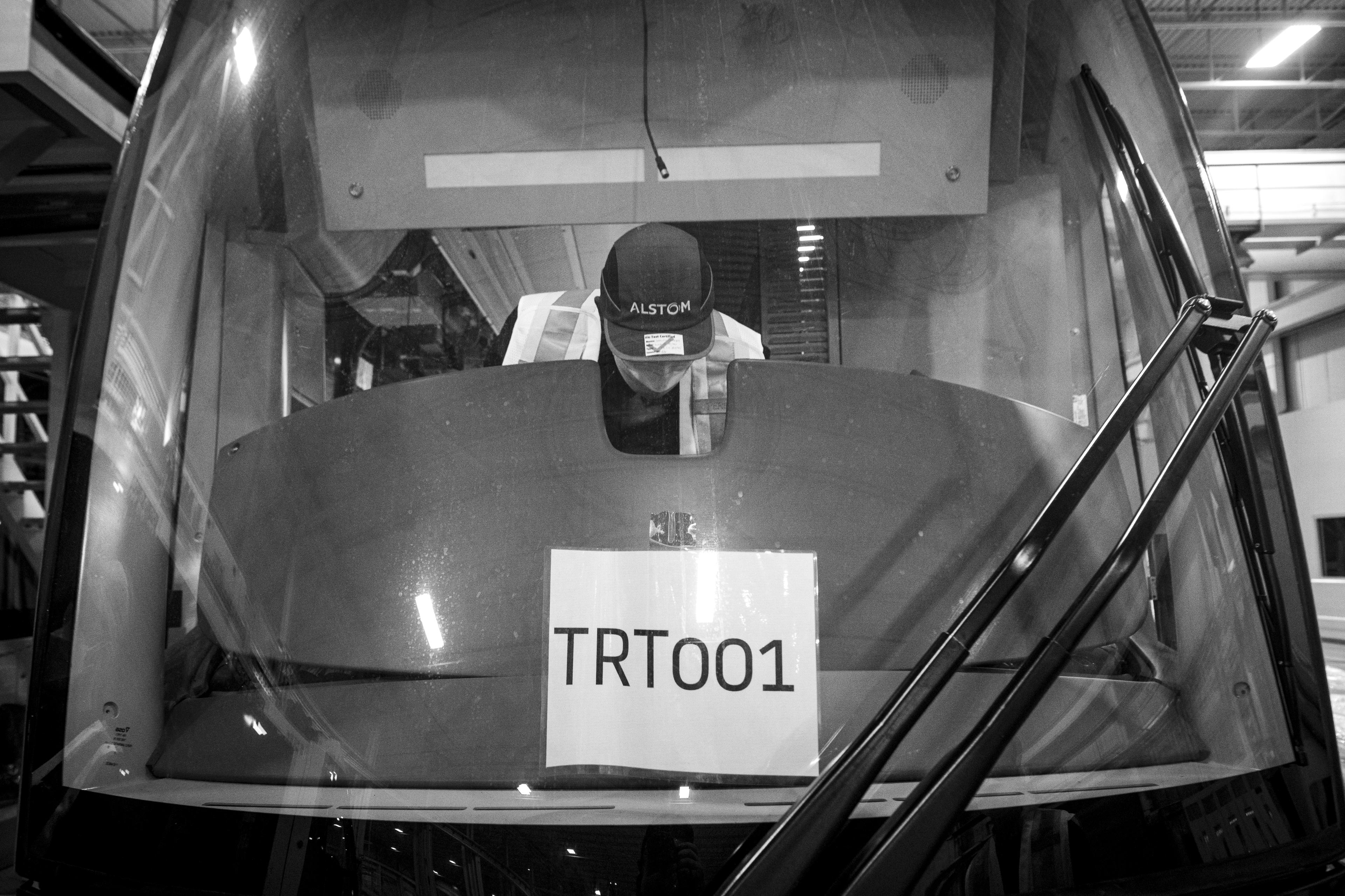A man is seen working behind the windshield of a transit vehicle.