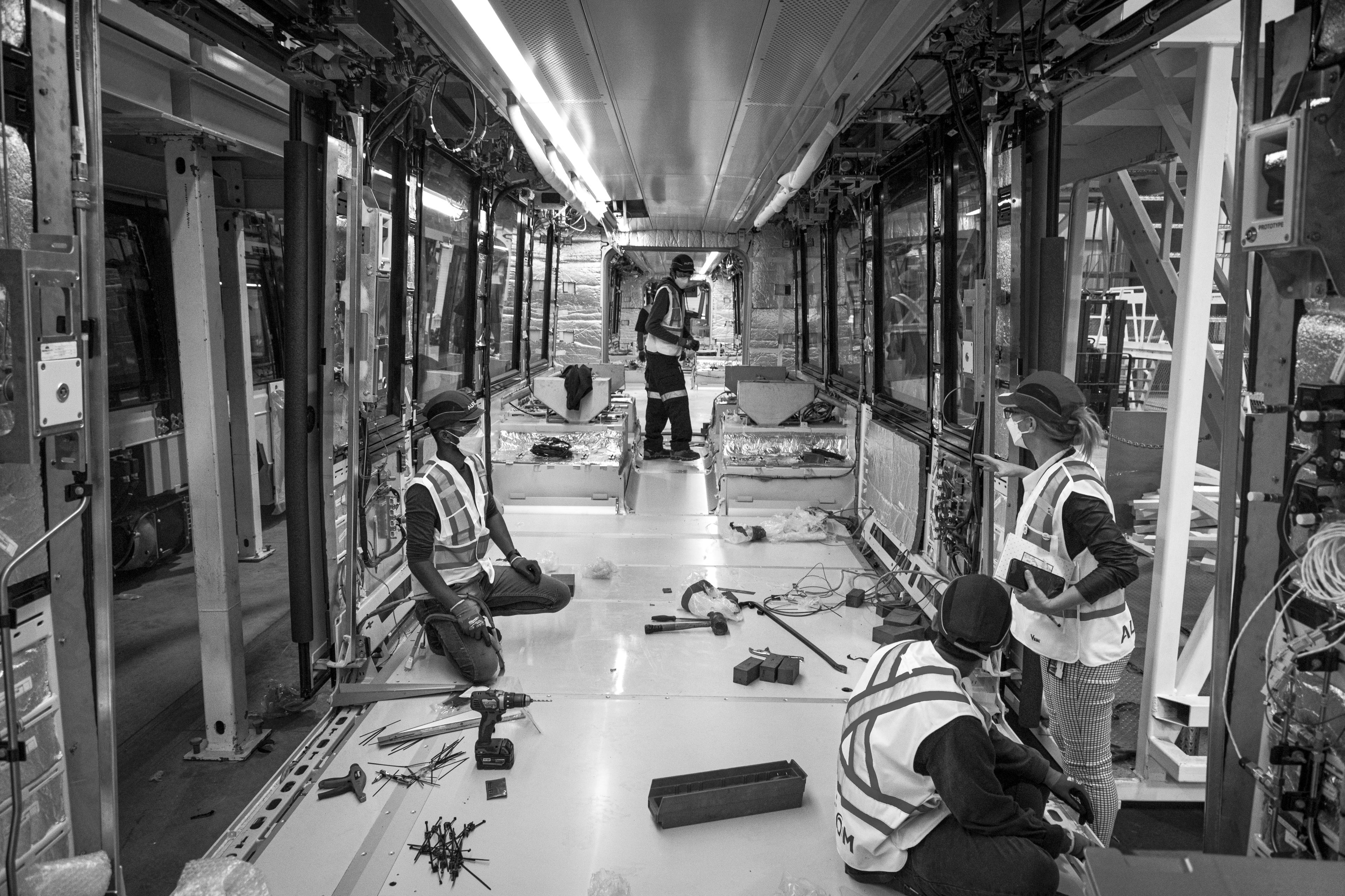 A crew works inside a vehicle.