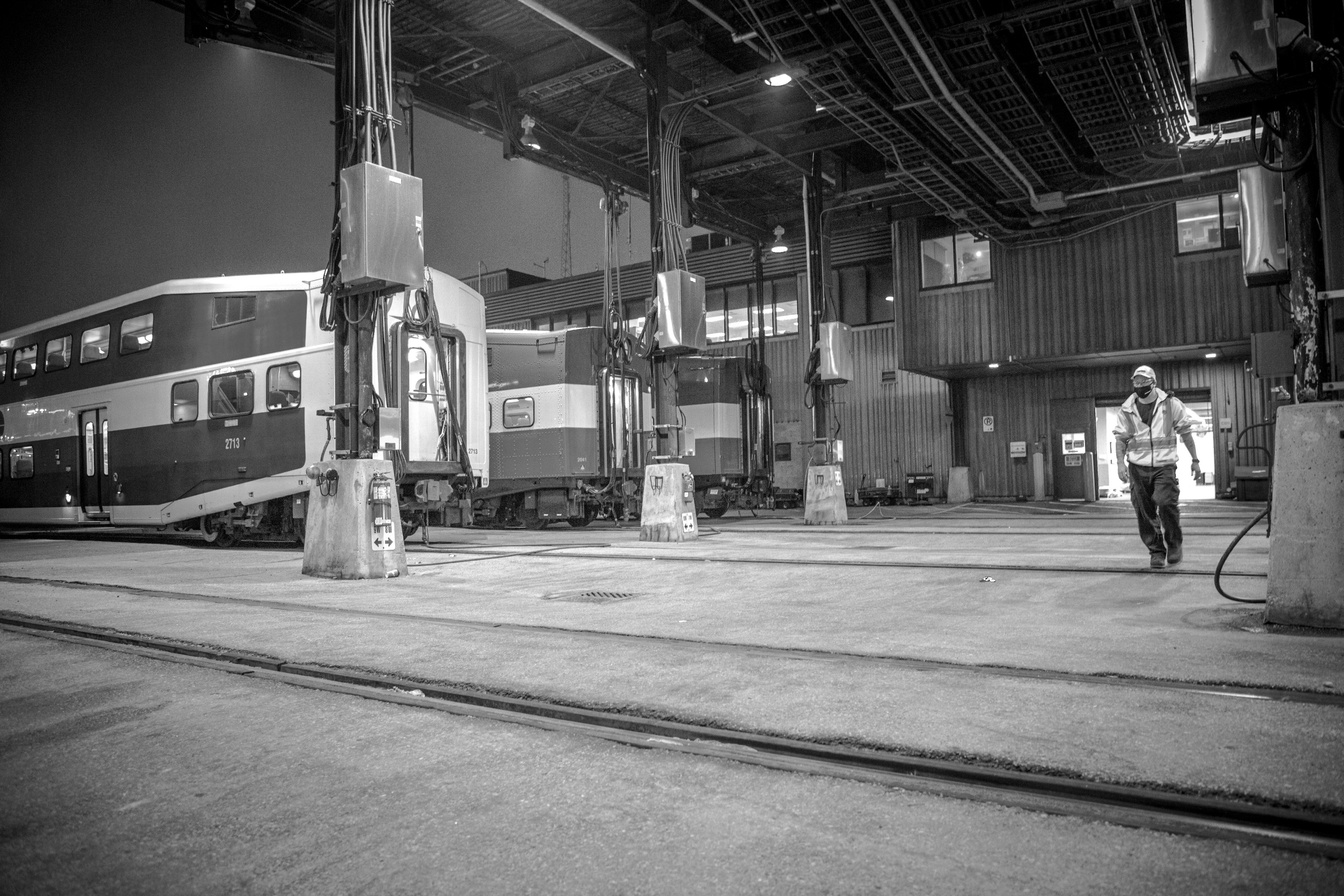 A man walks beside trains.