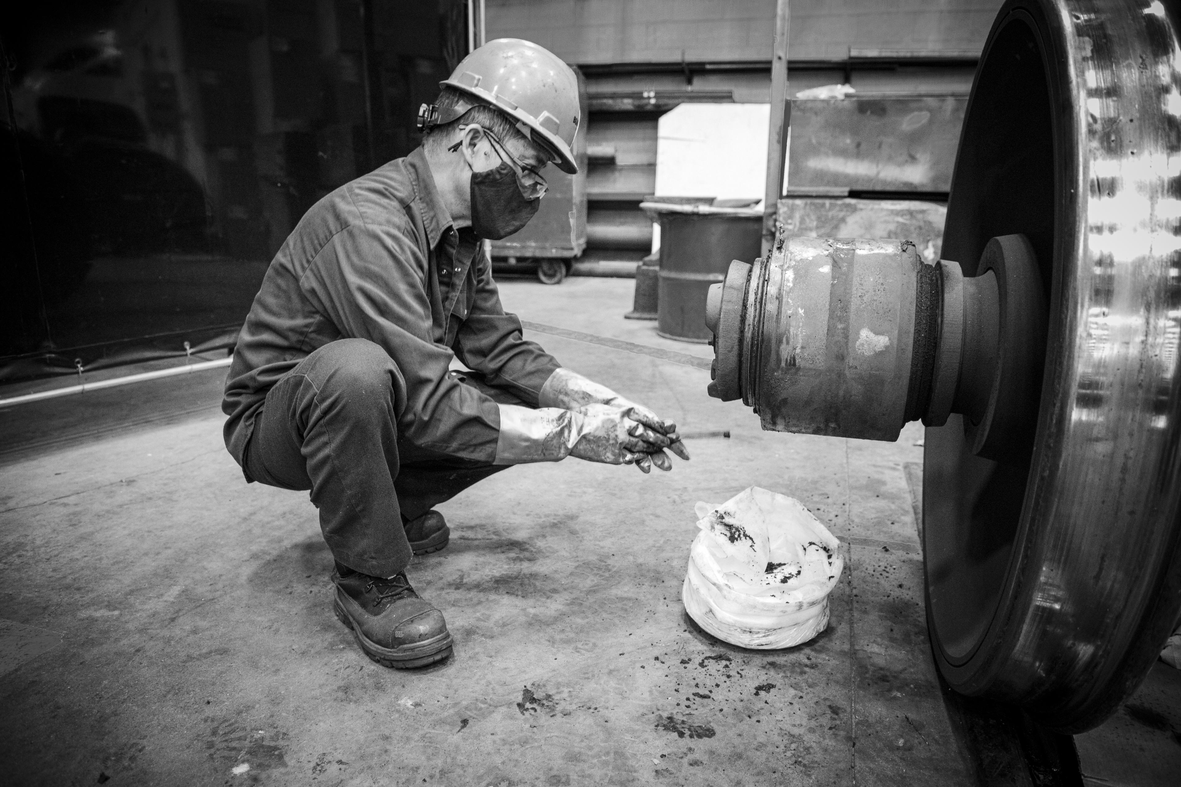 A man kneels down to work on a wheel.