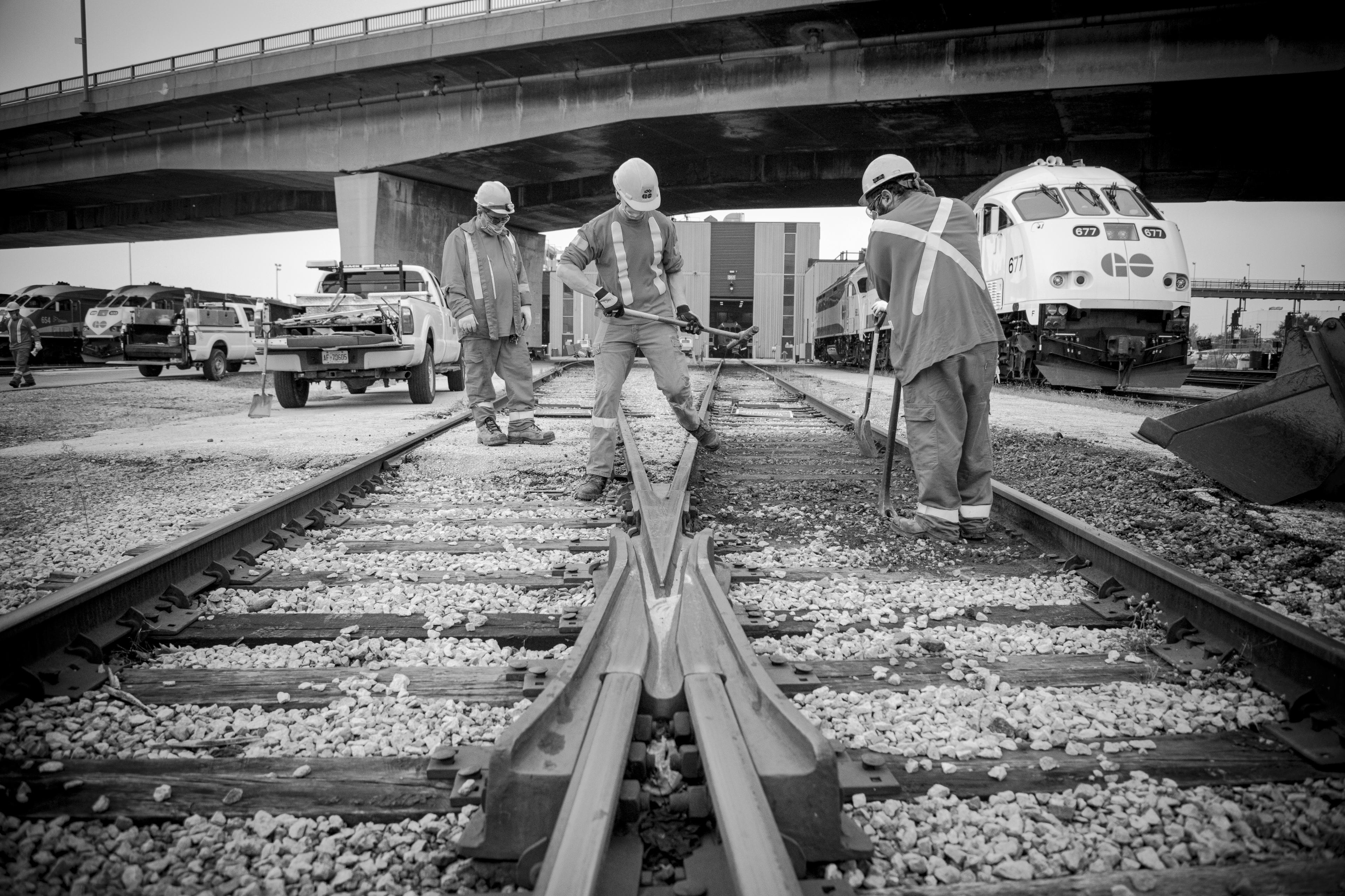 Three men work beside one another.