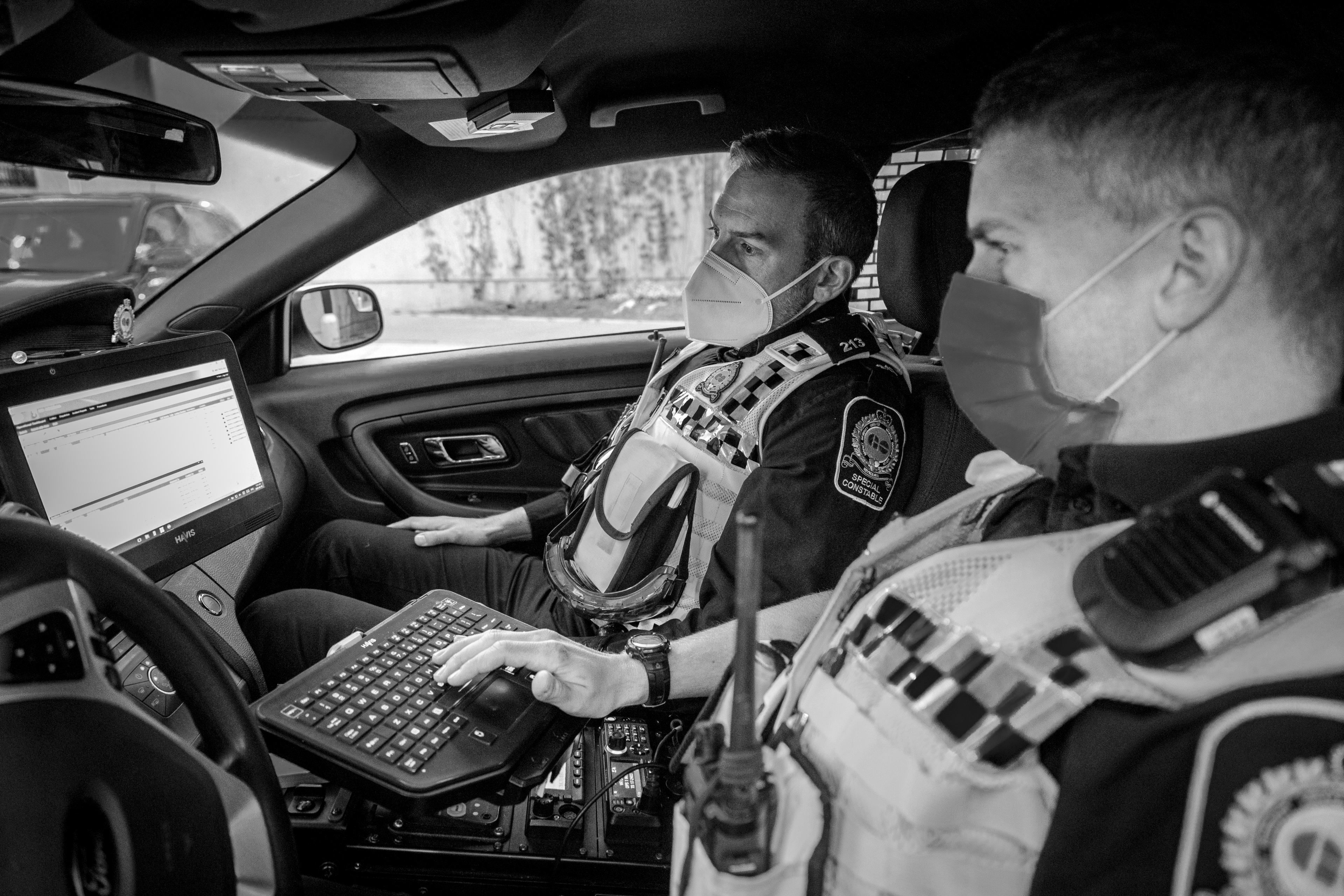 Two officers sit inside a vehicle.