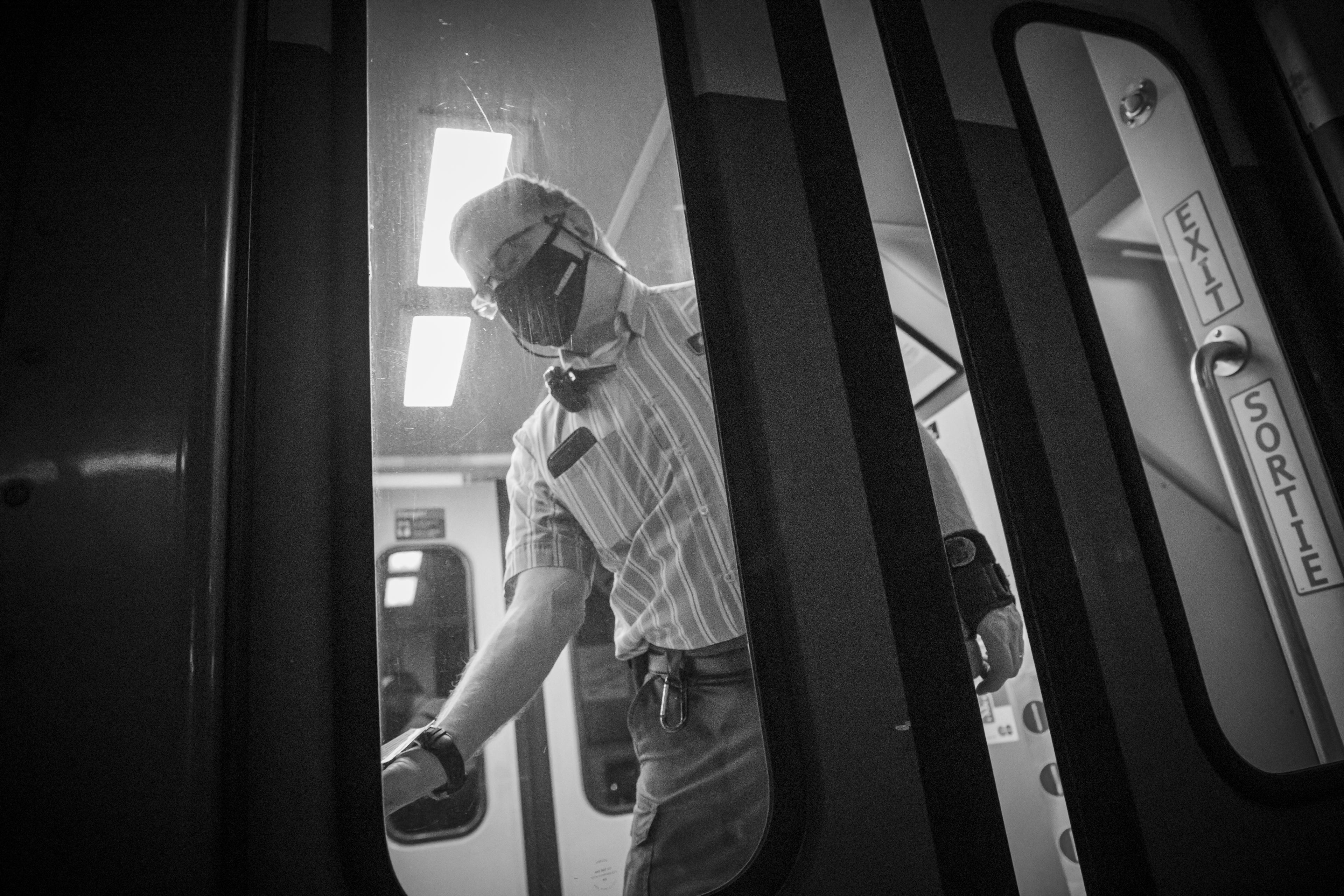 A man works on a train door.