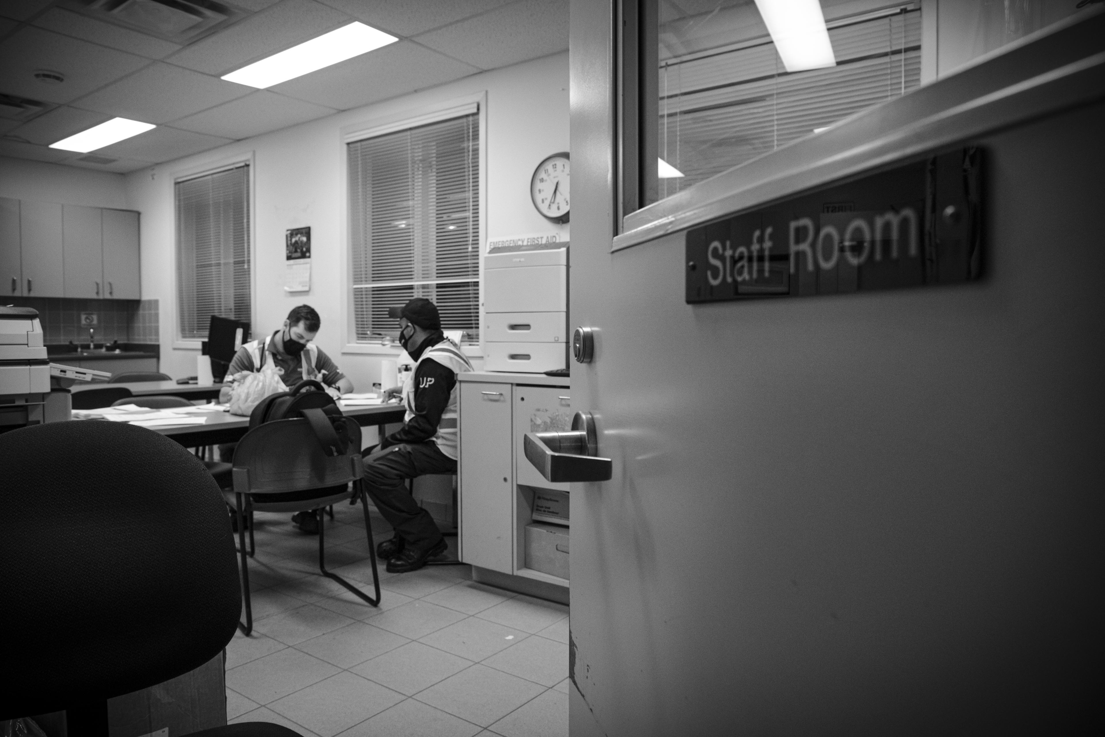 Men sit inside an office.