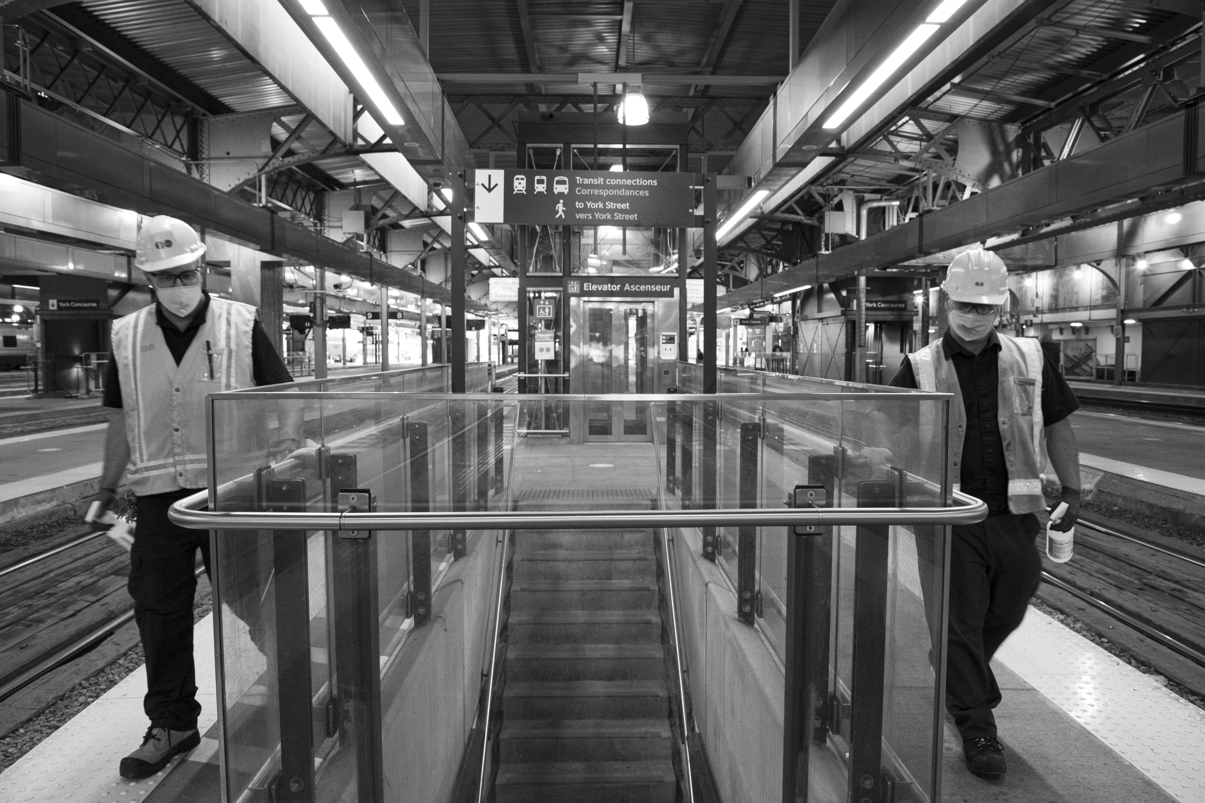 Two men clean hand rails.