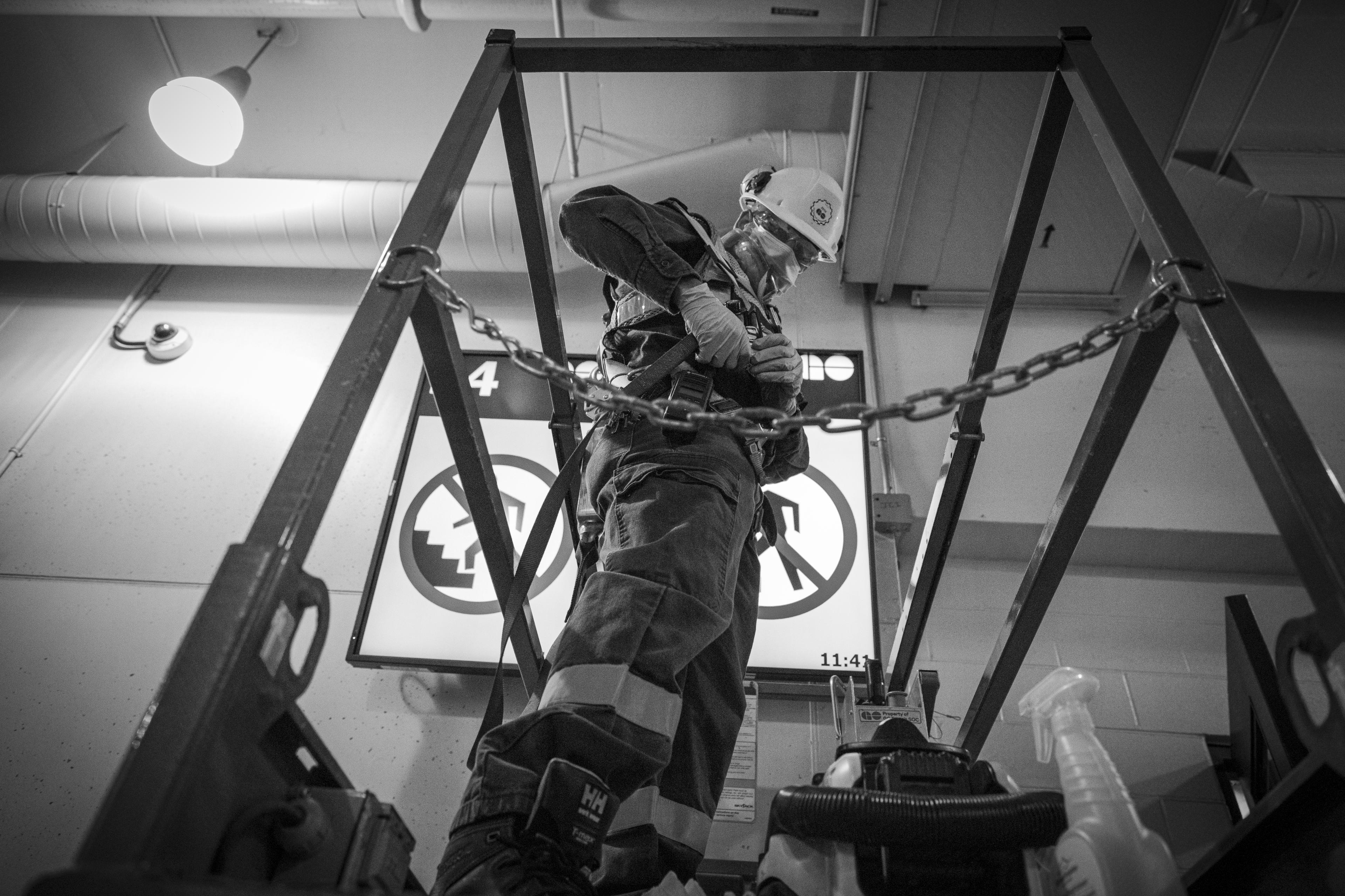 A man secures a support line onto his belt.