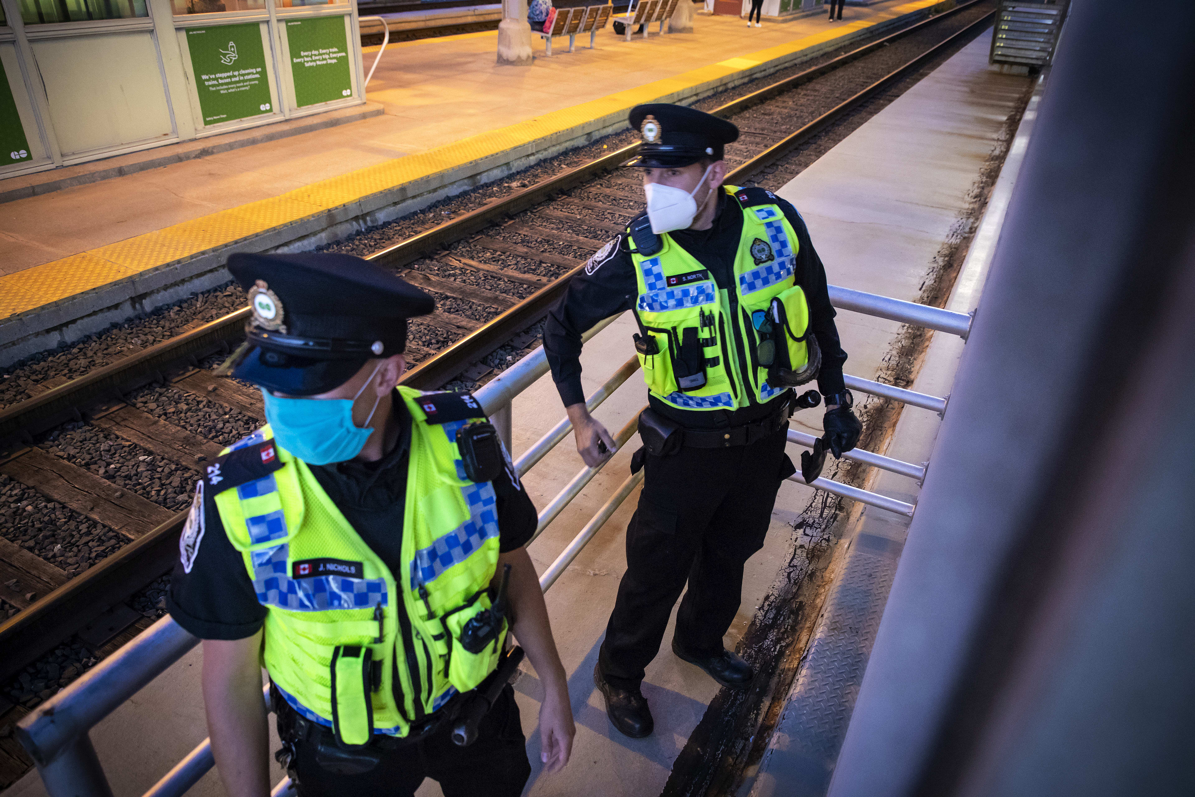 Two officers stare down the tracks.