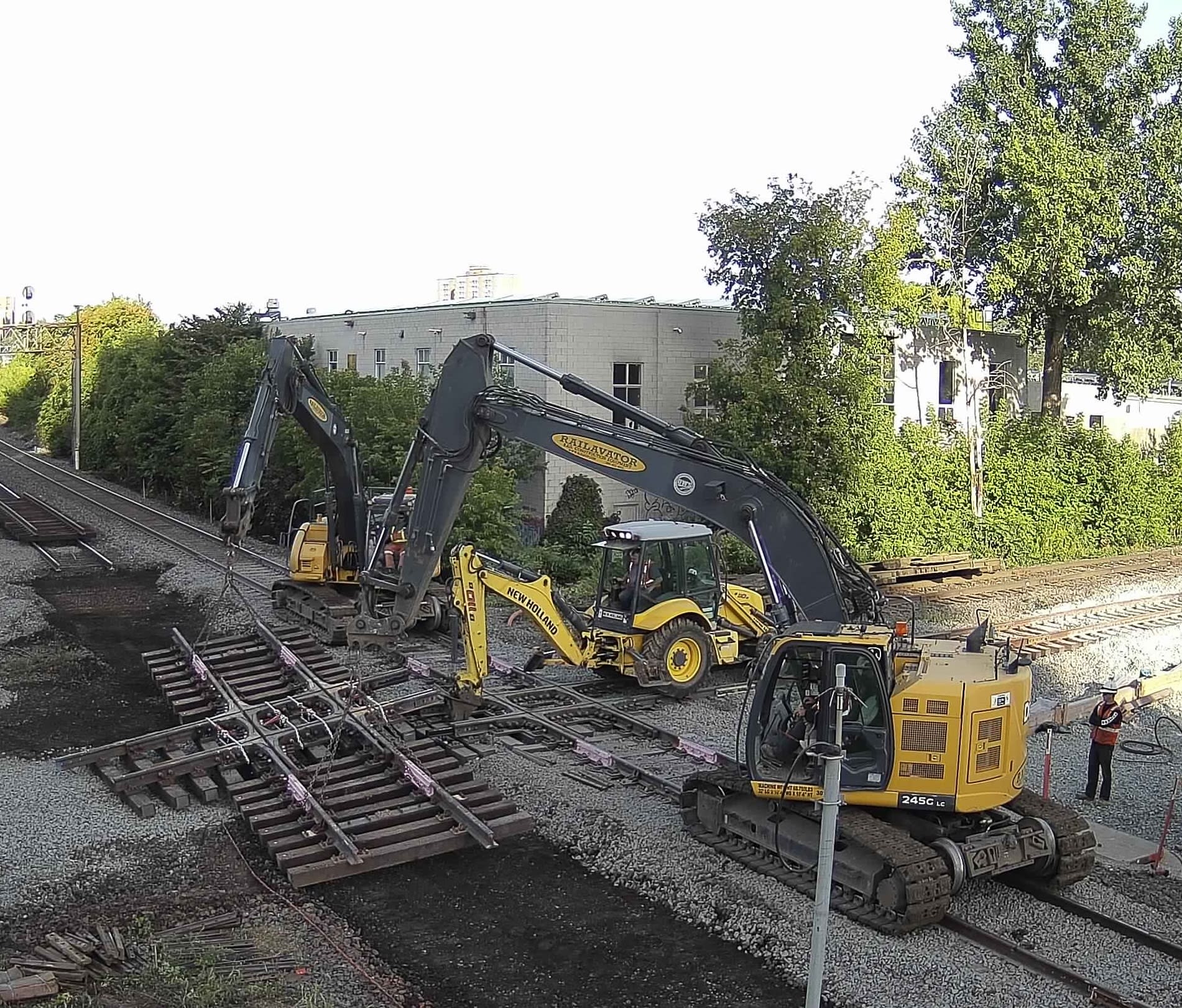 Tractors move a section of tracks.