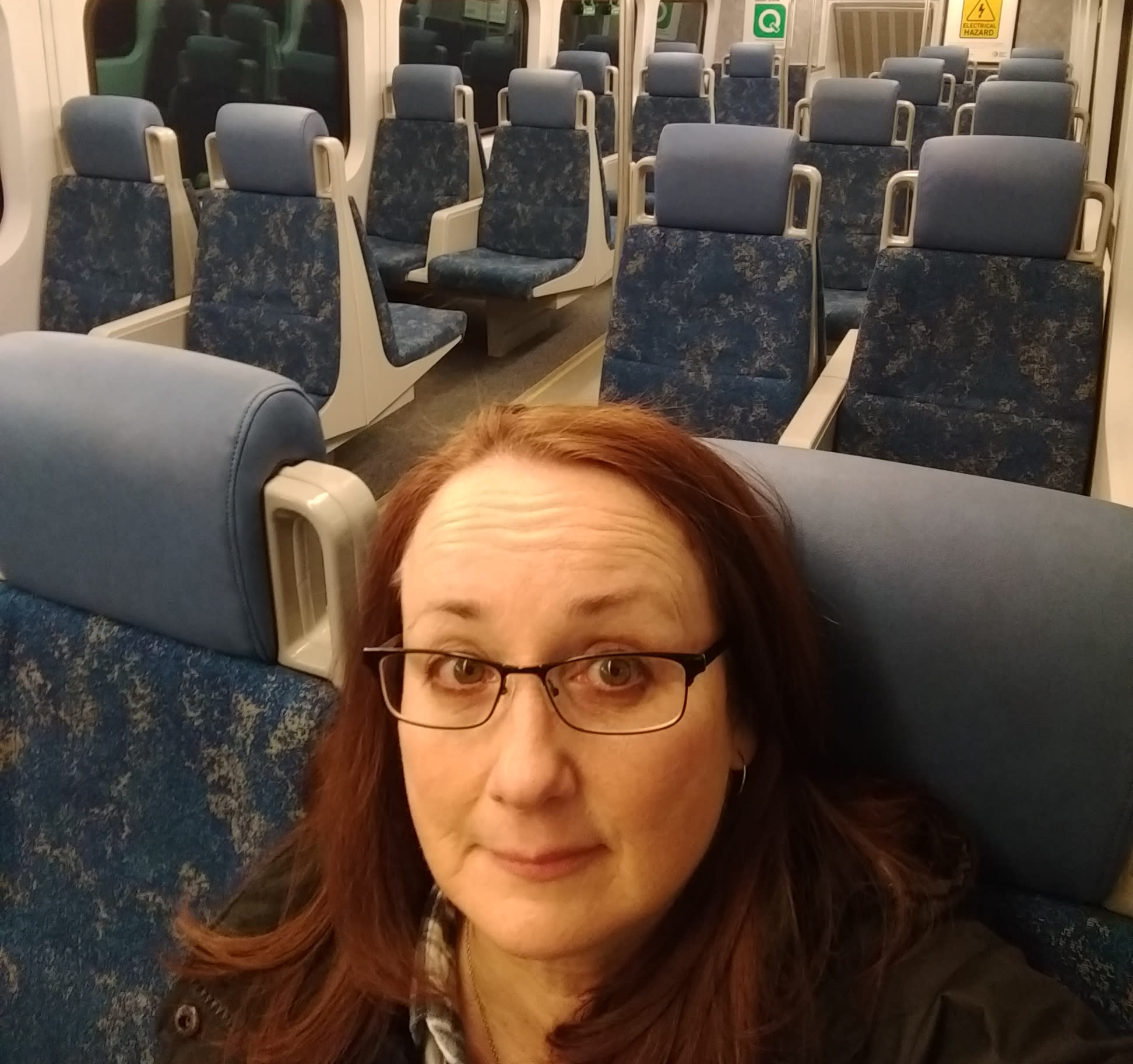 A GO customer takes a self of herself sitting in an empty train