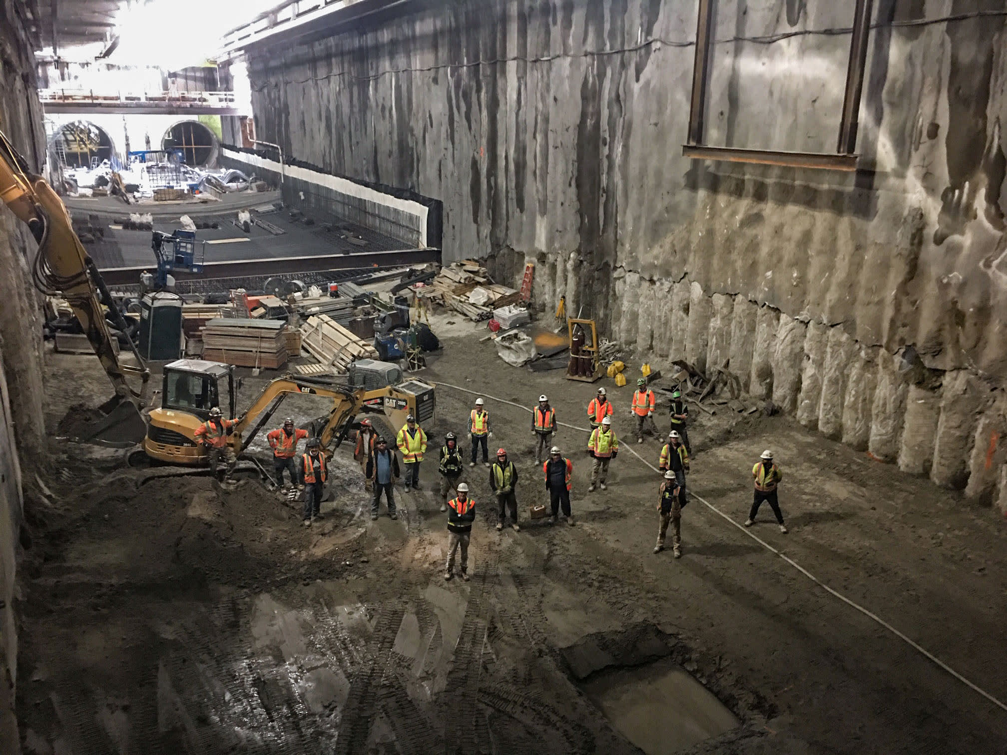 Crew stands at bottom of a large pit.