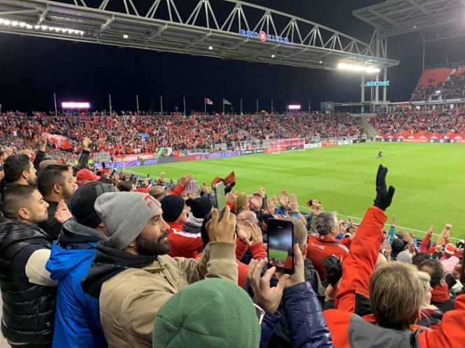 Fans cheer during a soccer game.