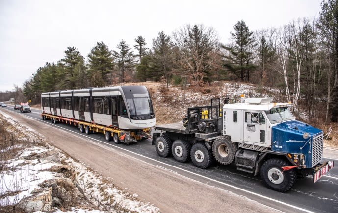 A truck hauls the LRV down a single-lane highway, as it heads toward Toronto.