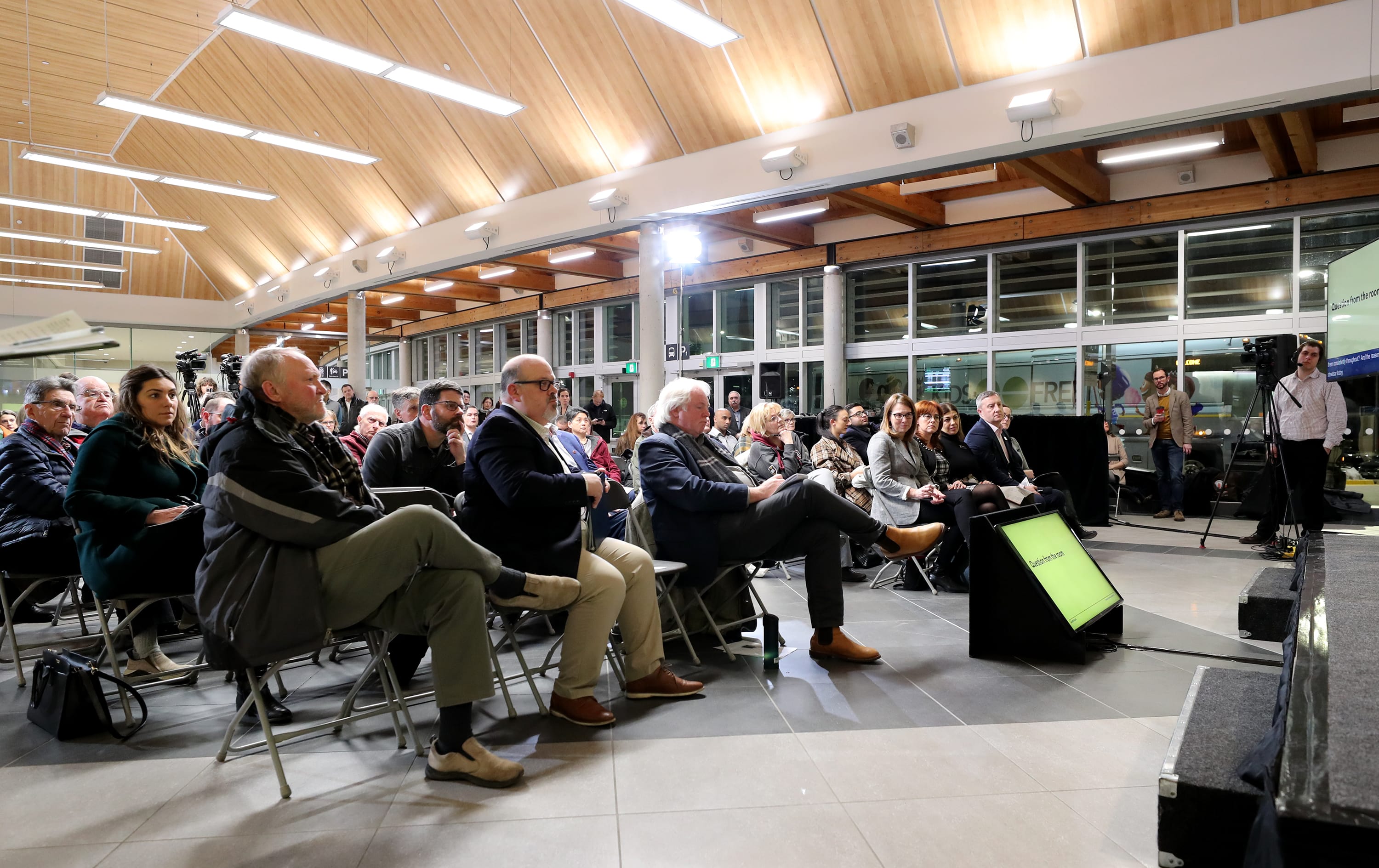 the crowd sitting on folded chairs inside the station.