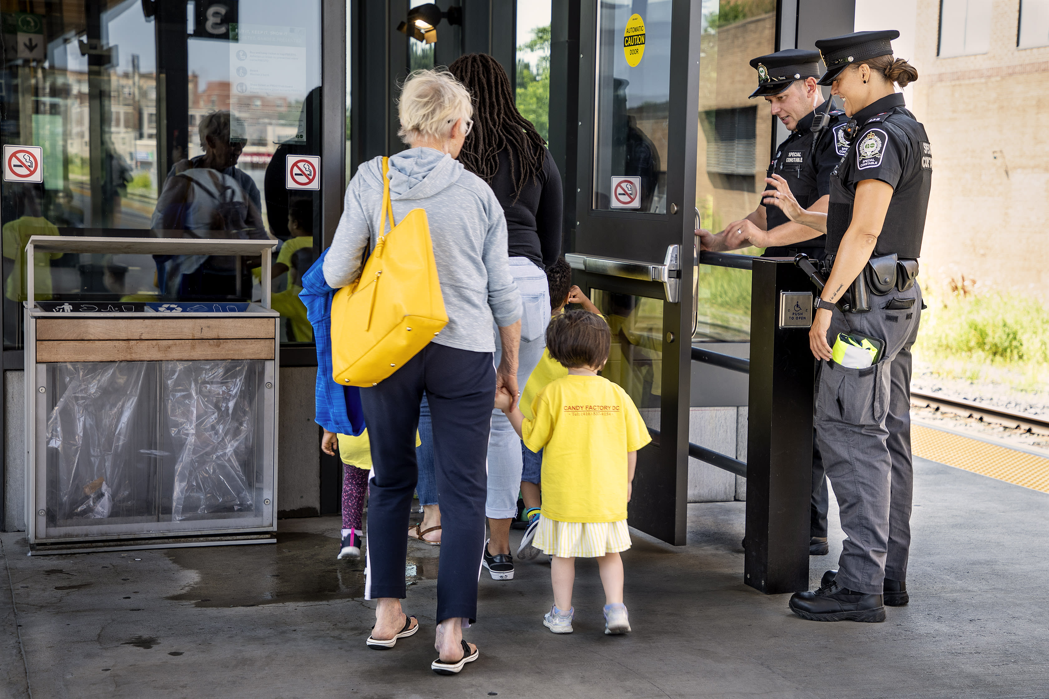 Children wave at transit safety officers as they leave the platform, on the way home.