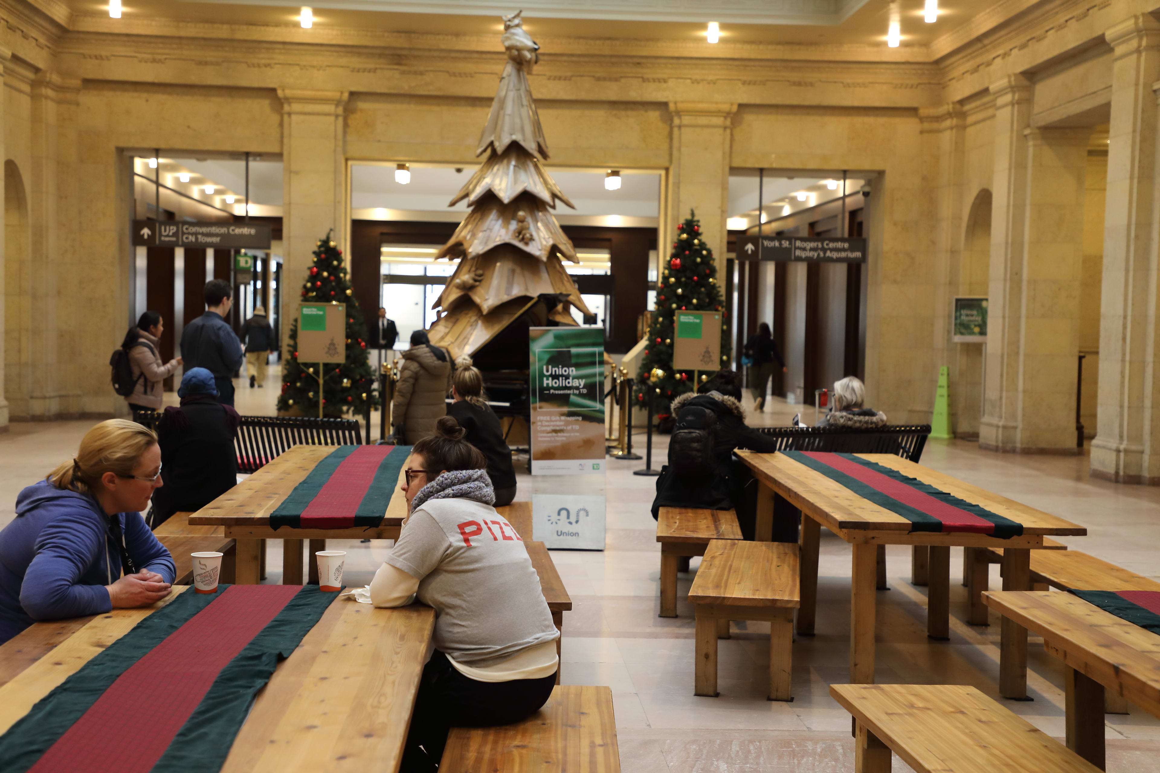 A wide shot of the west wing inside Union Station where christmas trees and long communal tables ...