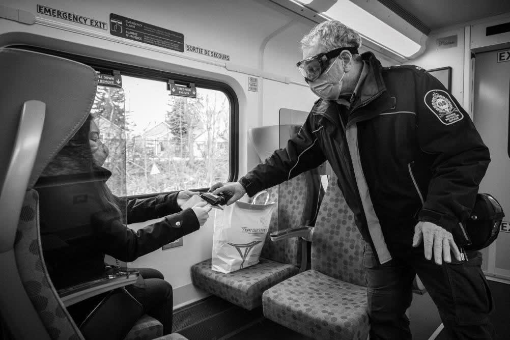 Revenue Protection Officer Shawn Miller checks the PRESTO card of a Lakeshore West customer on th...