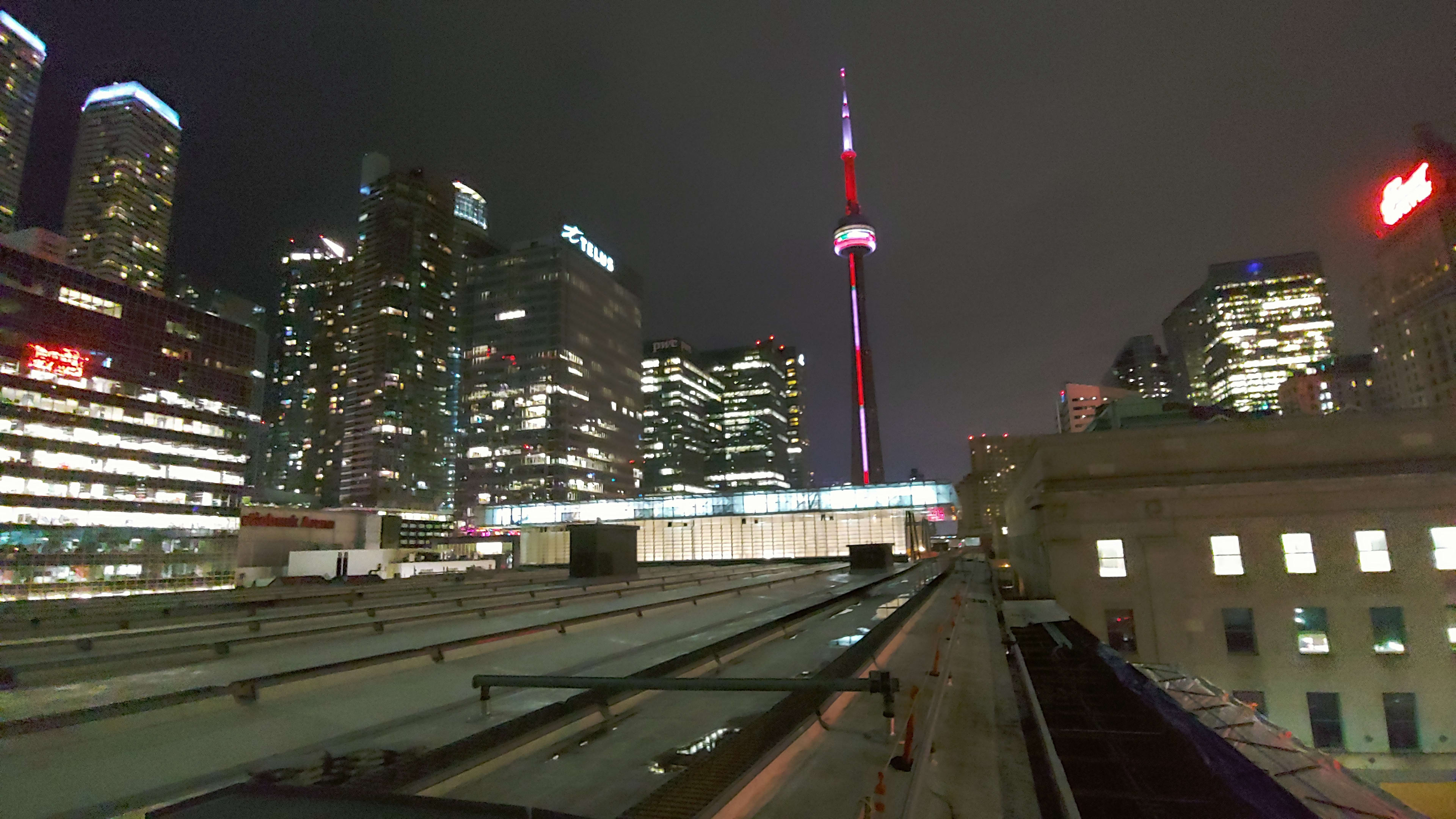 View of the trainshed at Union Station with the glowing CN Tower in the background.