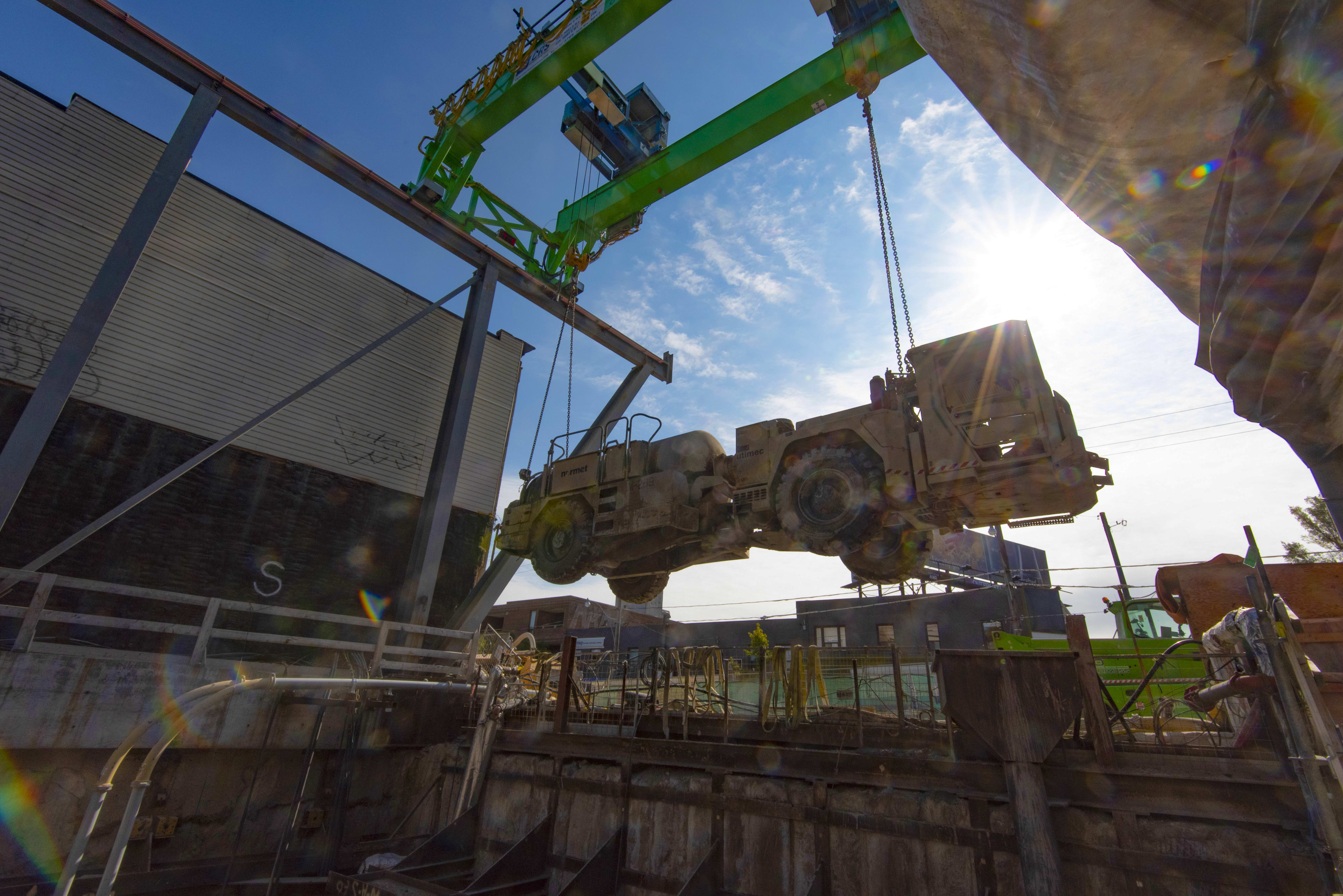 A crane lifts up a large vehicle from a site.