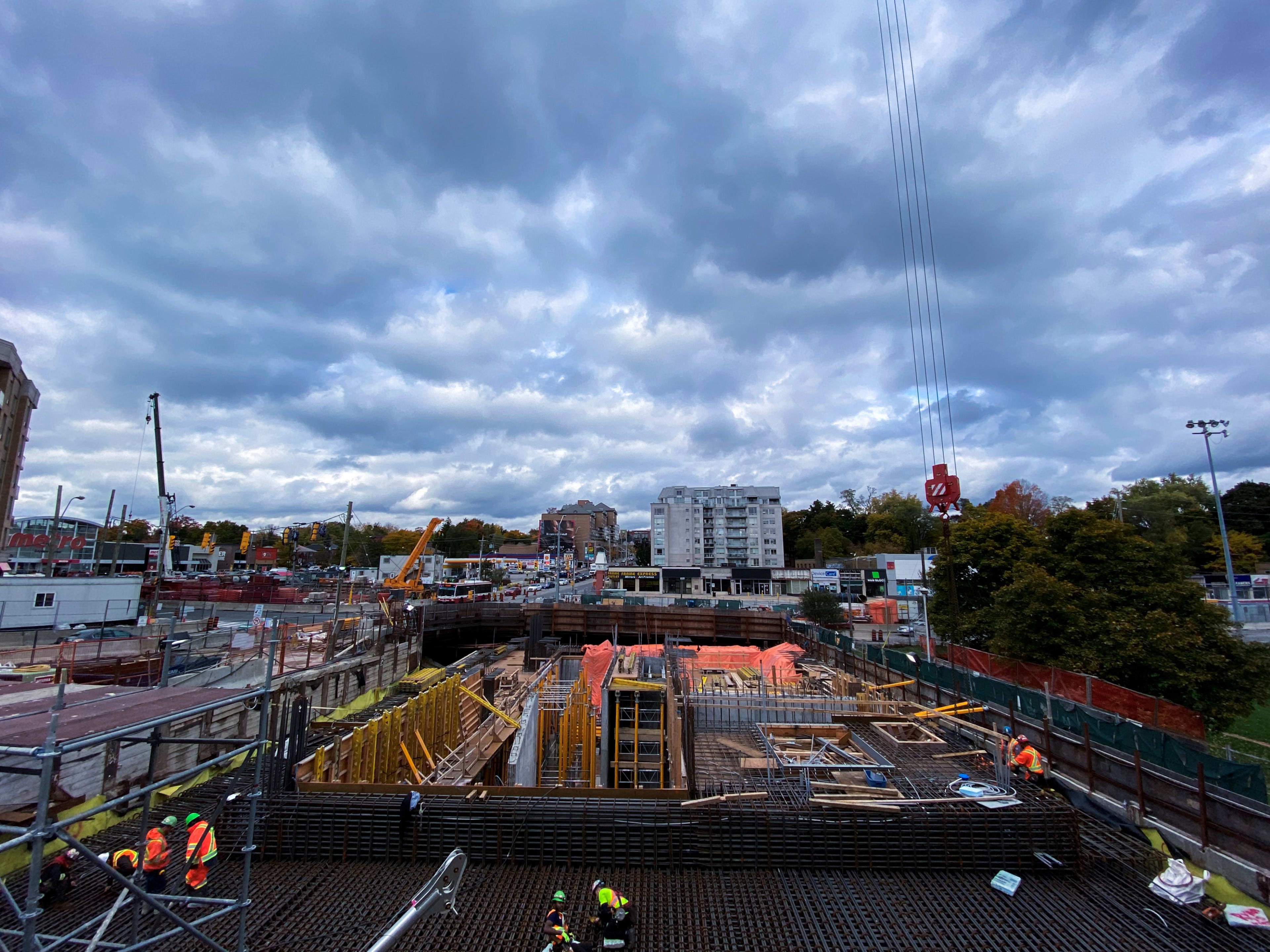 Workers toil around rebar in a large work area.